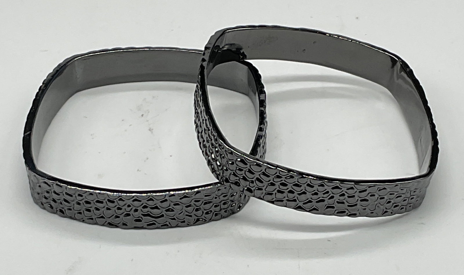 Pair Signed Gunmetal Textured Bangle Bracelets: Pair of signed gunmetal silver tone textured band square bangle bracelets. Measures approx. 2.25 inches wide. Includes a jewelry pouch. Some scratching. Jewelry, estate jewelry, costume jewelry,