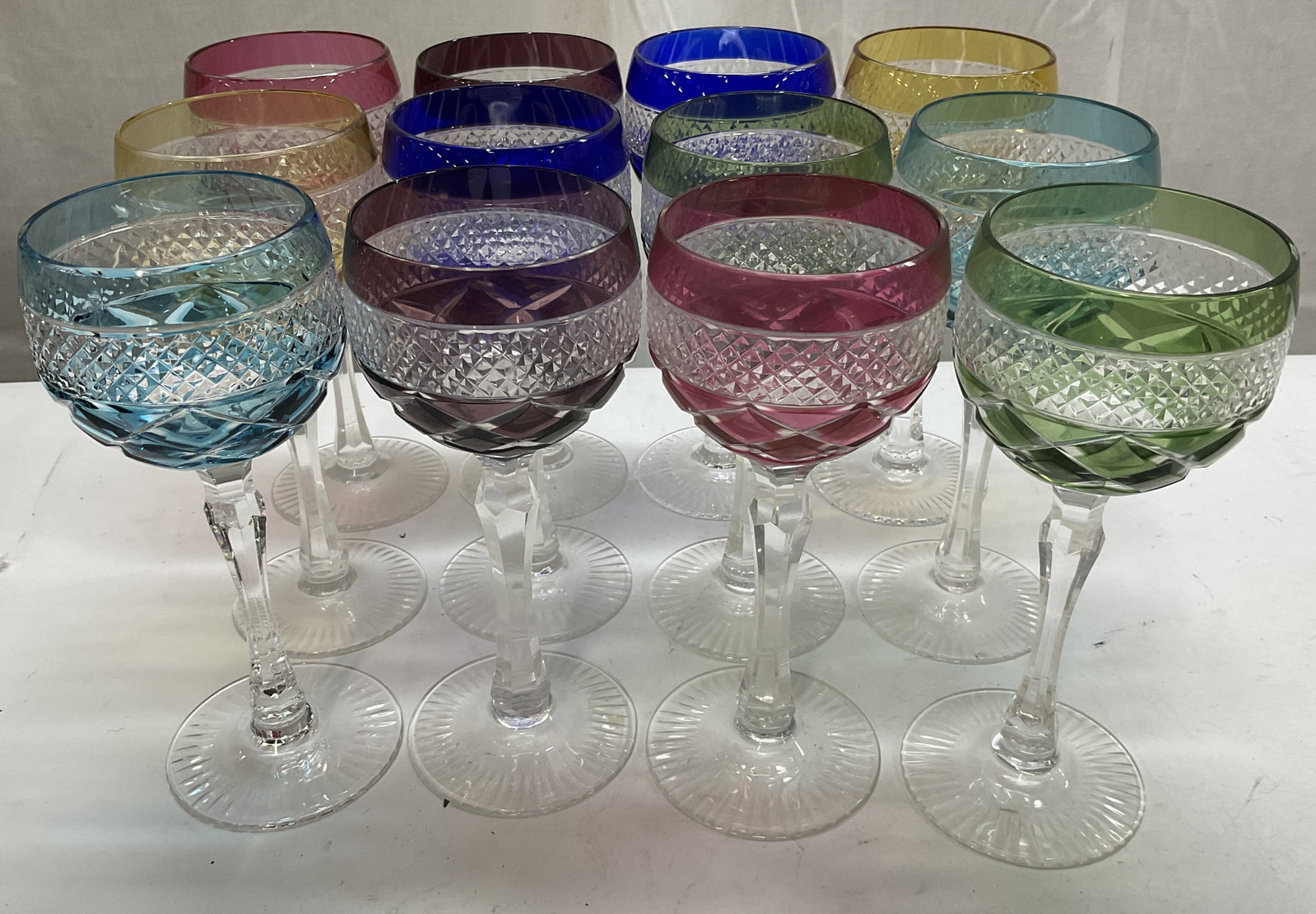 St 12 Colorful Bohemian Crystal Goblets: Set of 12 Colorful Bohemian Cut-To-Clear Crystal Goblets. 2 Light Blue, 2 Purple, 2 Pink, 2 Olive Green, 2 Yellow, and 2 Cobalt Blue. Condition Consistent With Exposure. Measures app 7.75in H x 3in