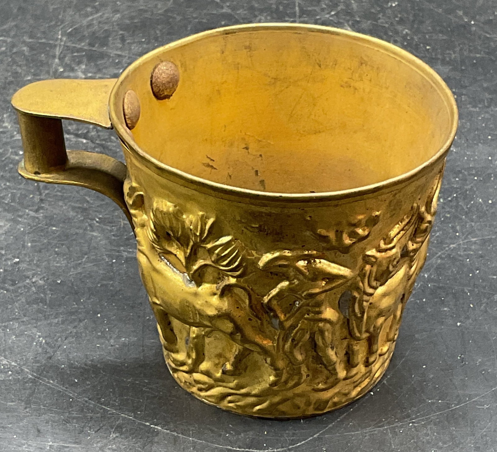 Mycenae Replica Brass Bull Cup: Mycenae replica cup. Brass with raised bull catching scene. Measures approx. 4 x 3 x 2.75 inches. Wear including scratching, patina, warping. Mycenae cup, brass cup, bull cup, collectibles, home decor