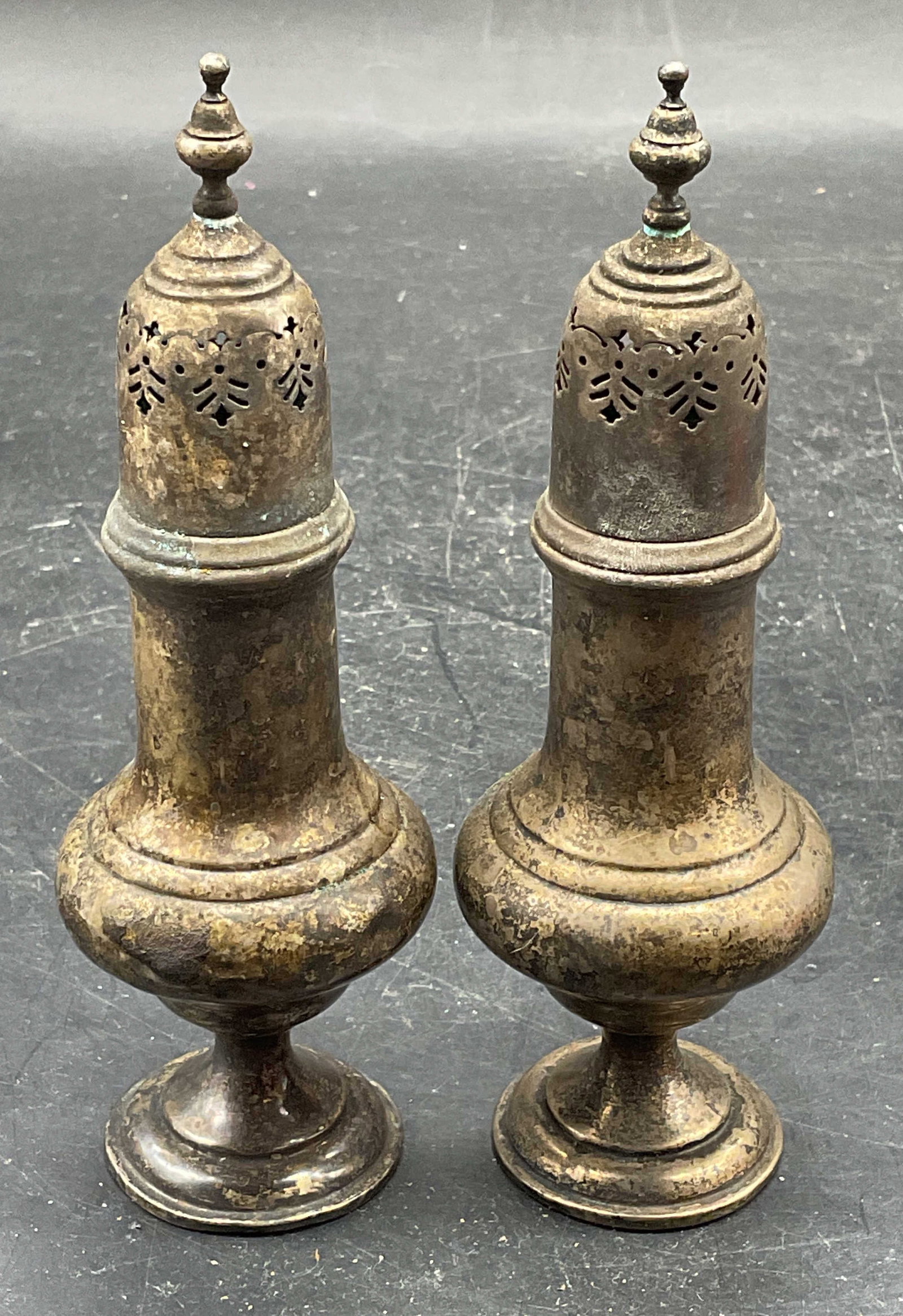 Vintage Pair Sterling Silver Sugar Shakers: Vintage pair of sterling silver sugar shakers/muffineers. Marked sterling, 441. Measures approx. 1.75 x 5.25 inches. Total weight 119 grams. Wear including patina, scratching, warping, tops appear stu