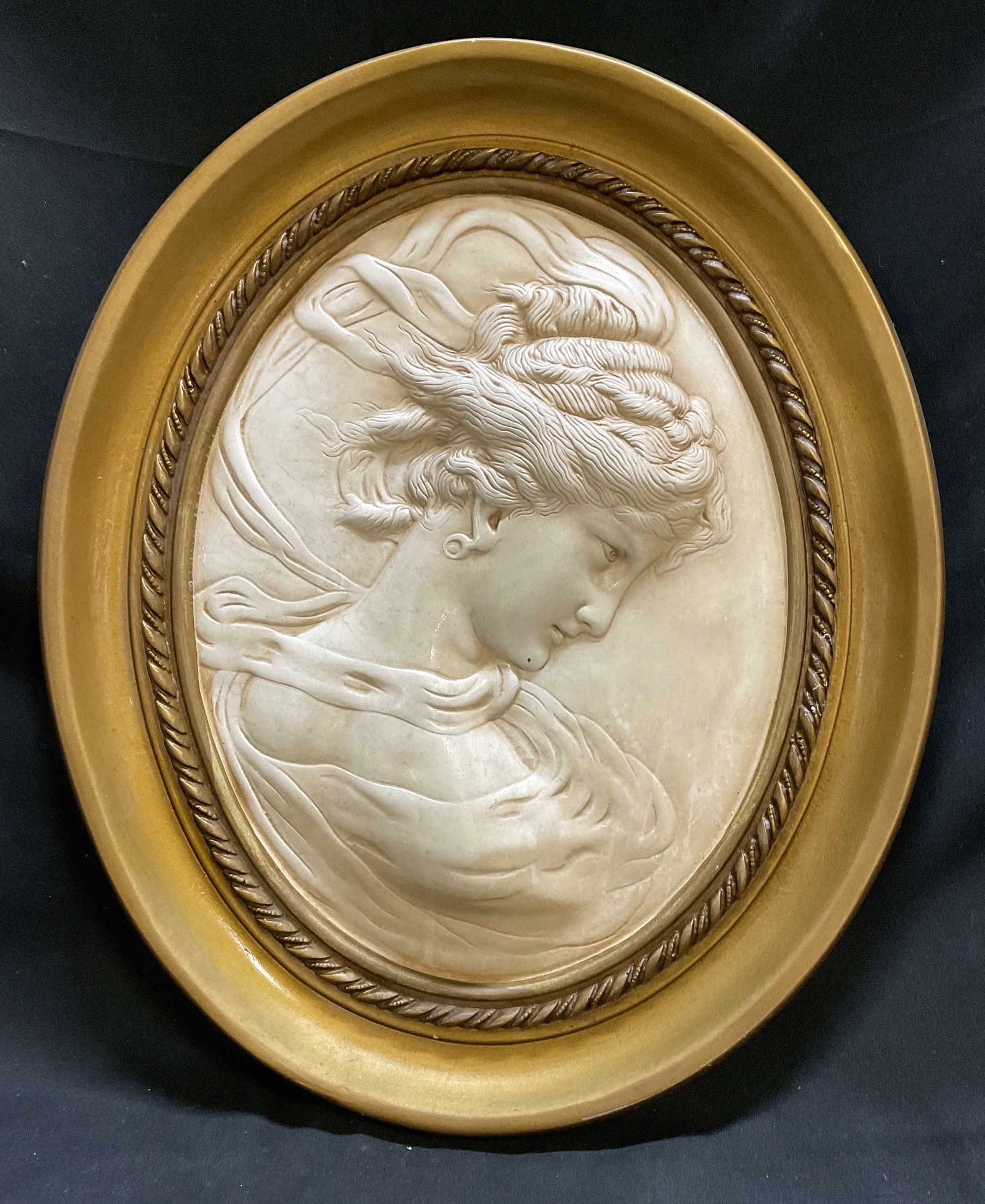 VTG Neoclassical Lady Cameo 17.25in Wall Plaque: Vintage Chalkware Neoclassical Lady Cameo Wall Plaque. Raised Portrait Decorated with Gold-Toned Oval Frame. Some Cracks, Scratching, and Marks. Measures app 17.25in H x 14.5in Diam. Vintage, Chalkwar