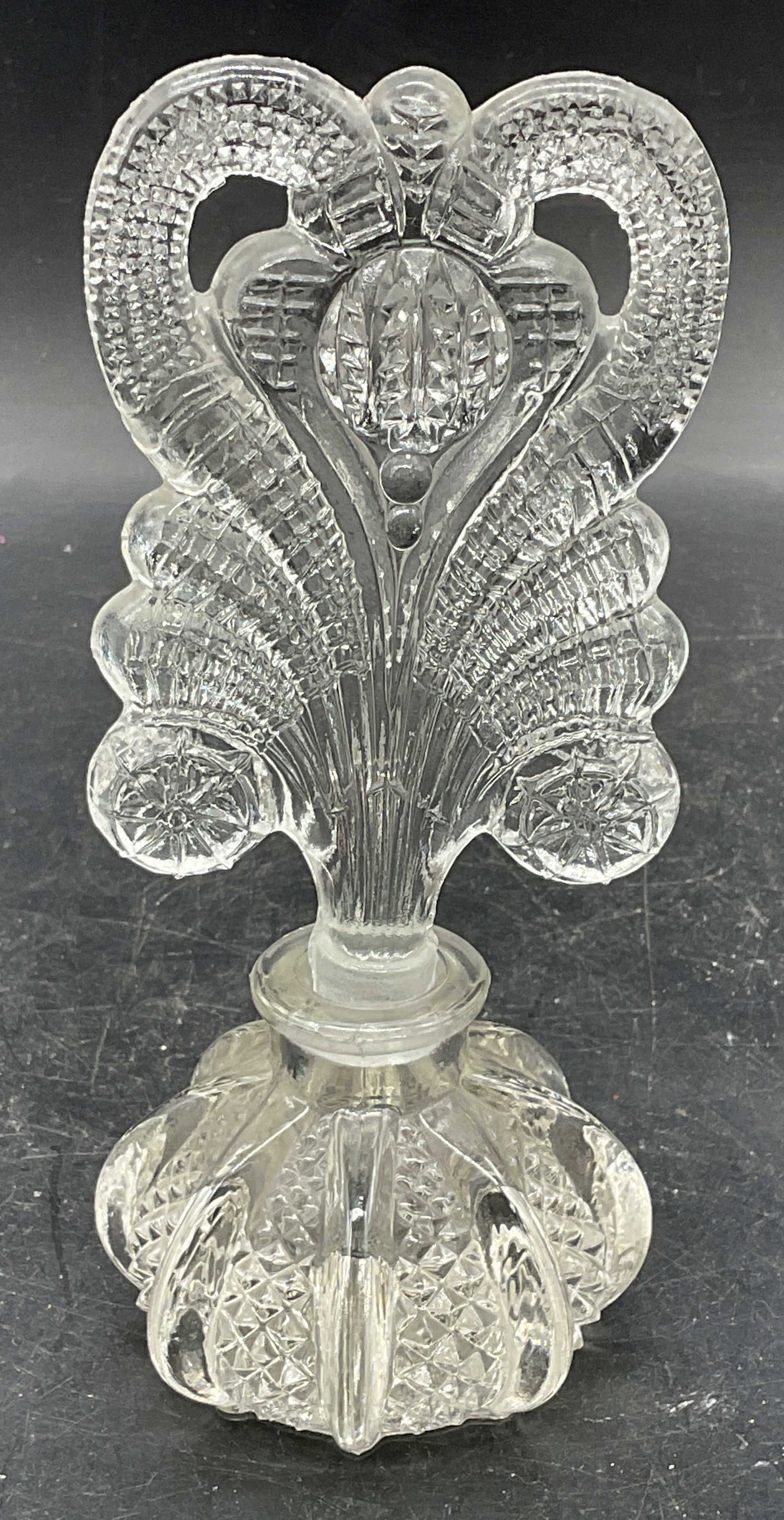 Vintage Ornate Glass Perfume Bottle & Stopper: Vintage pressed glass perfume bottle and stopper with ornate design. Ribbed and diamond pattern on bottle. Bottle measures approx. 2.75 x 2.25 inches. Stopper measures approx. 2.75 x 4.5 inches. Some 