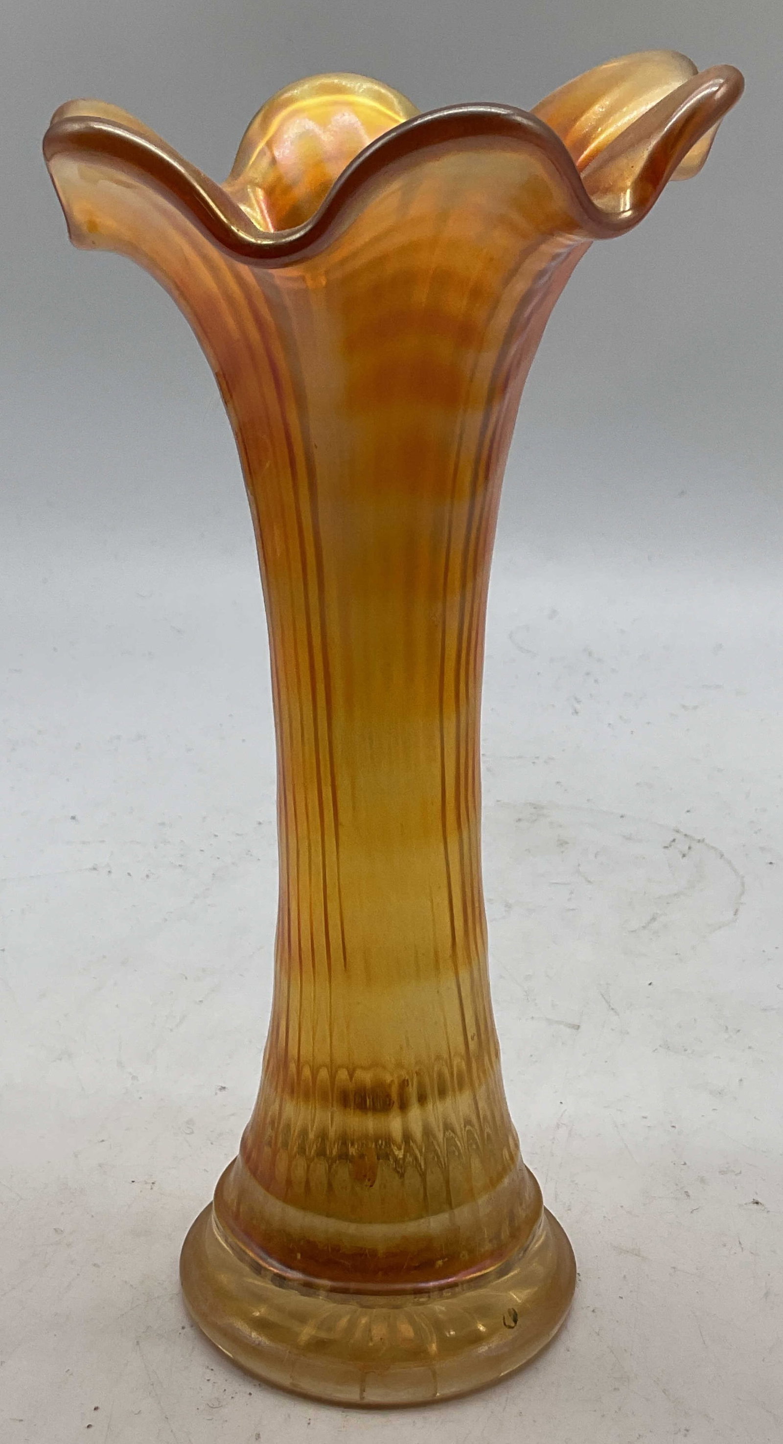 Vintage Marigold Carnival Glass Swung Vase: Vintage marigold carnival glass swung vase. Round base. Scalloped and ruffled edge. Pulled rippled design. Measures ht approx 7.5 inches diam approx 2.5 inches. Surface wear consistent with exposure. 