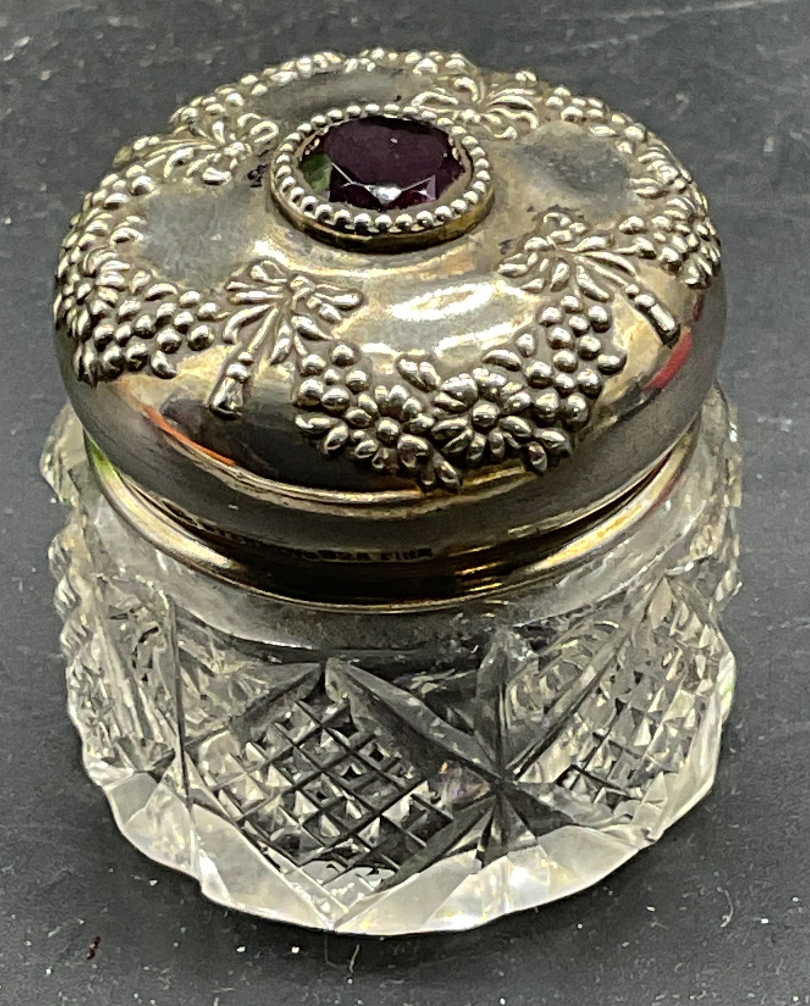 Vtg Signed Sterling Silver Cut Glass Powder Jar: Vintage sterling silver lidded cut glass powder jar. Diamond pattern jar with ornate repousse lid. Faux amethyst crystal set into lid. Marked sterling. Signed with makers mark. Measures approx. 1.25 x