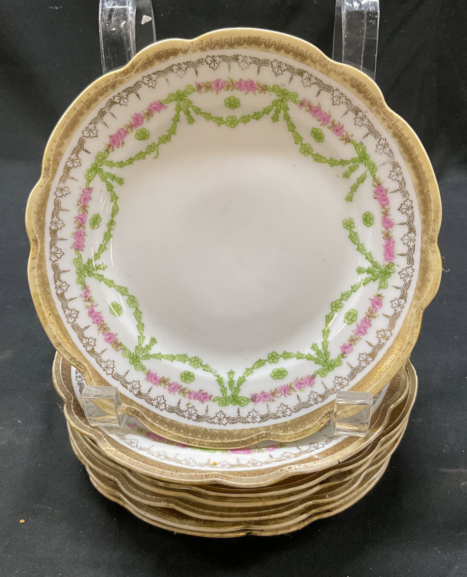 Set 7 Moritz Zdekauer Porcelain Plates Austria: Set of 7 Moritz Zdekauer porcelain plates. Marked MZ Austria on underside. Round plates. Scalloped gilt edge. Gilt accents. Pink and green floral and scroll motifs. Measures approx 6.5 inches in diame