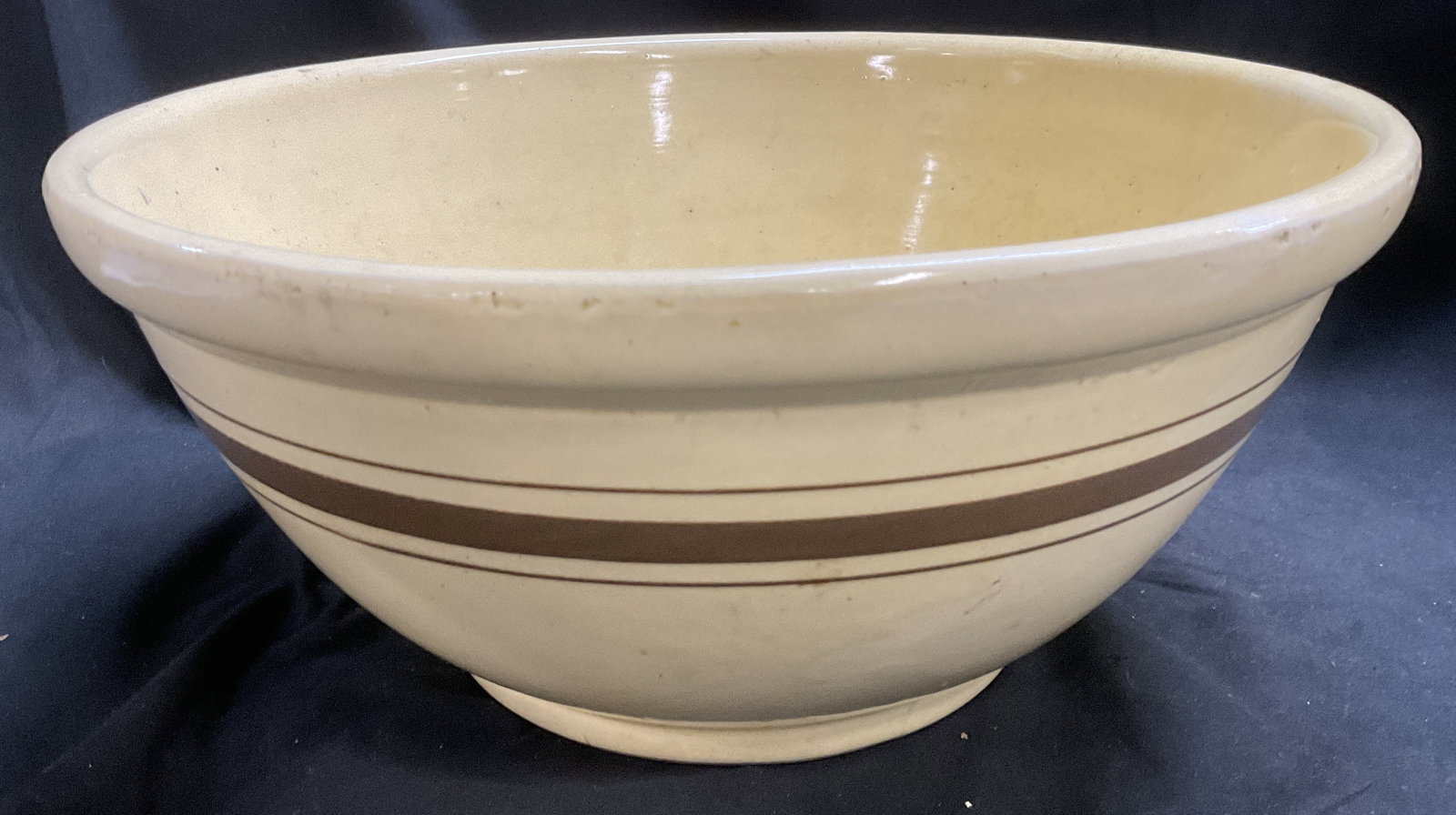 ANTQ Yellow Ware Striped Mixing Bowl: Antique Yellow Ware Brown Striped Mixing Bowl. Crafted from Firing Clay. Crazing, Chips, and Residue Present. Measures app 7in H x 15.5in Diam. Antique Pottery, Yellow Ware, Brown Stripes, Banded Stri