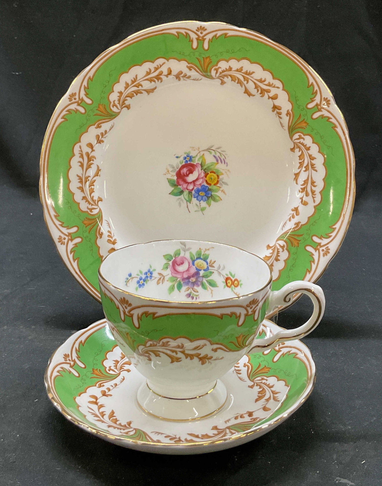 Set 3 Tuscan Teacup, Saucer, Plate England: Set of 3 items. Tuscan bone china teacup, saucer, and plate. Marked on underside, reads Tuscan Fine English Bone China Made In England. Scalloped gilt edge. Green and gilt scroll motifs. Central