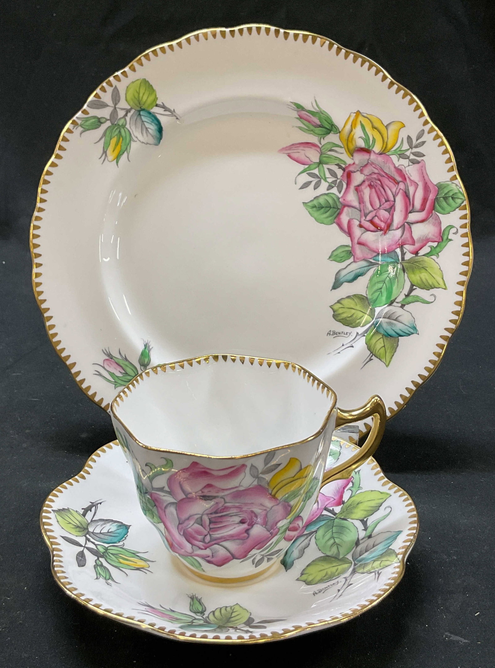 Set 3 Rosina Teacup, Saucer, Plate England: Set of 3 items. Rosina bone china teacup, saucer, and plate. Marked on underside, reads Rosina Bone China Made In England. Scalloped gilt edge. Signed A. Bentley. Floral motifs in varying colors.