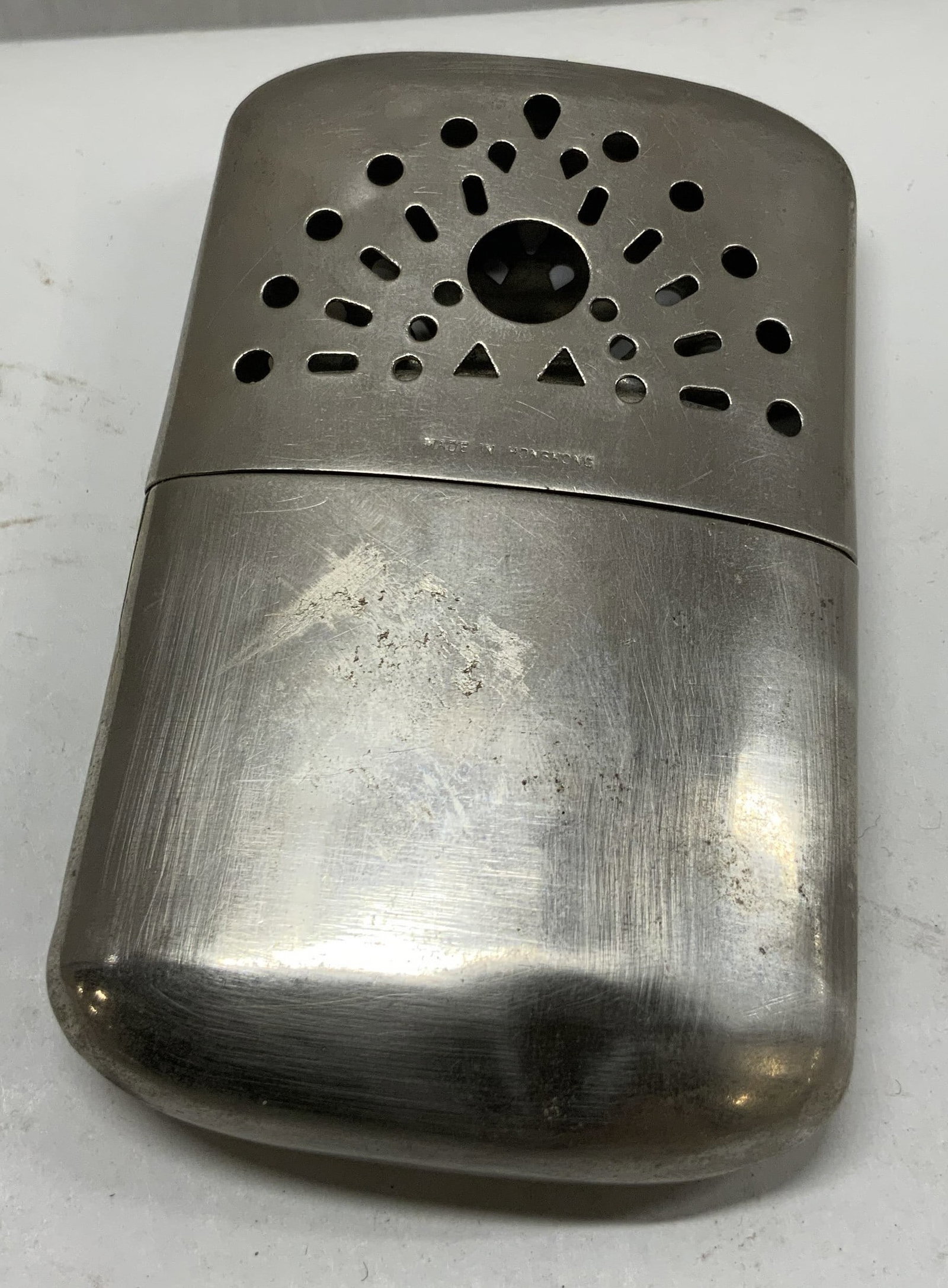 VTG Silver-Toned Fuel-Based Hand Warmer: Vintage Silver-Toned Fuel-Based Hand Warmer. Openwork Fan-Shaped Pattern. Made in Hong Kong. Surface Wear Such as Denting, Scratching, and Residue Present. Not Tested for Functionality. Measures app