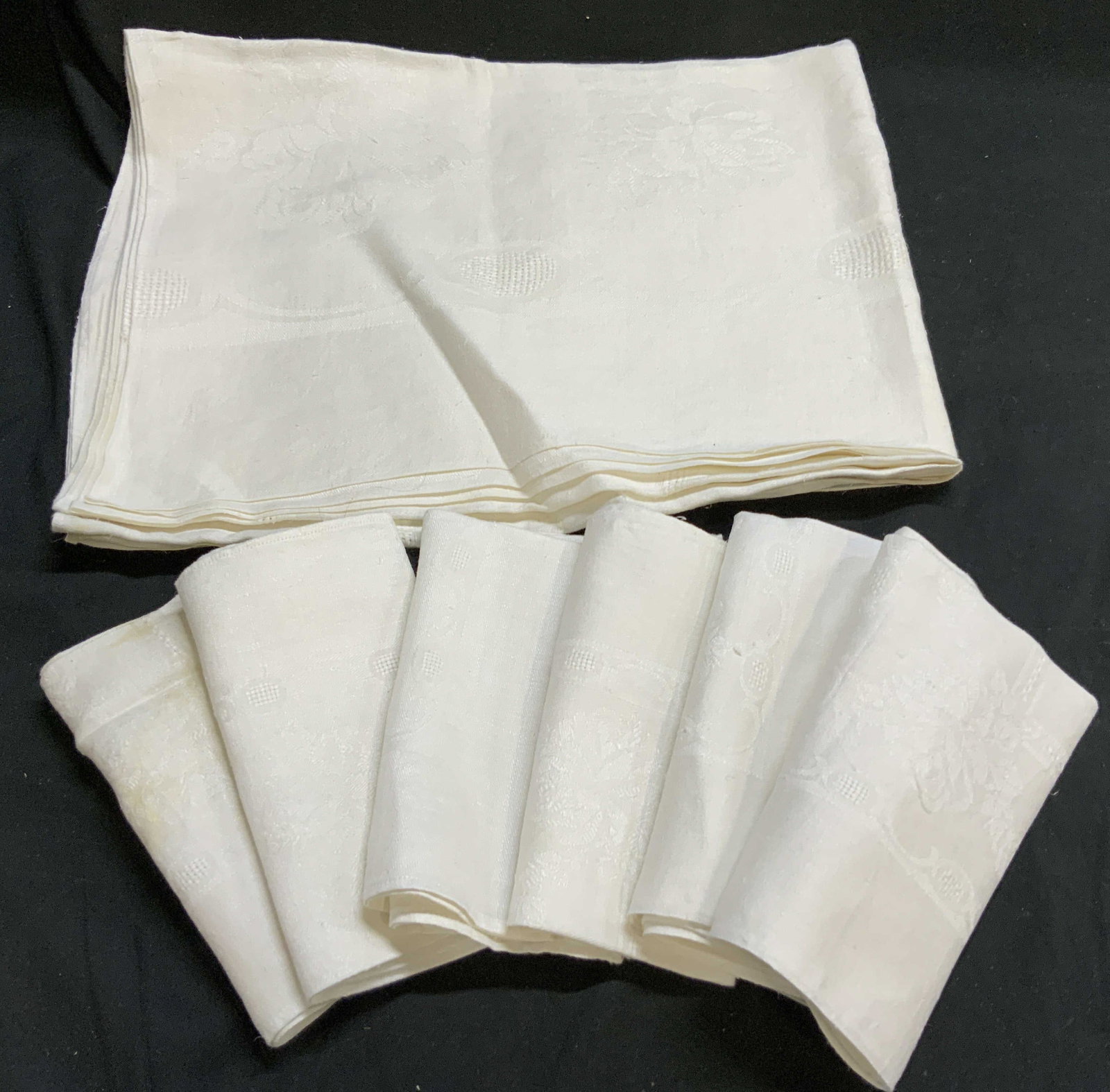 Set Vintage Tablecloth And 6 Napkins: White on white embroidered pattern on vintage linens have some table cloth and matching napkins, each napkin measures approximately 15 inches square, some yellowing, measures approximately 52 by 65