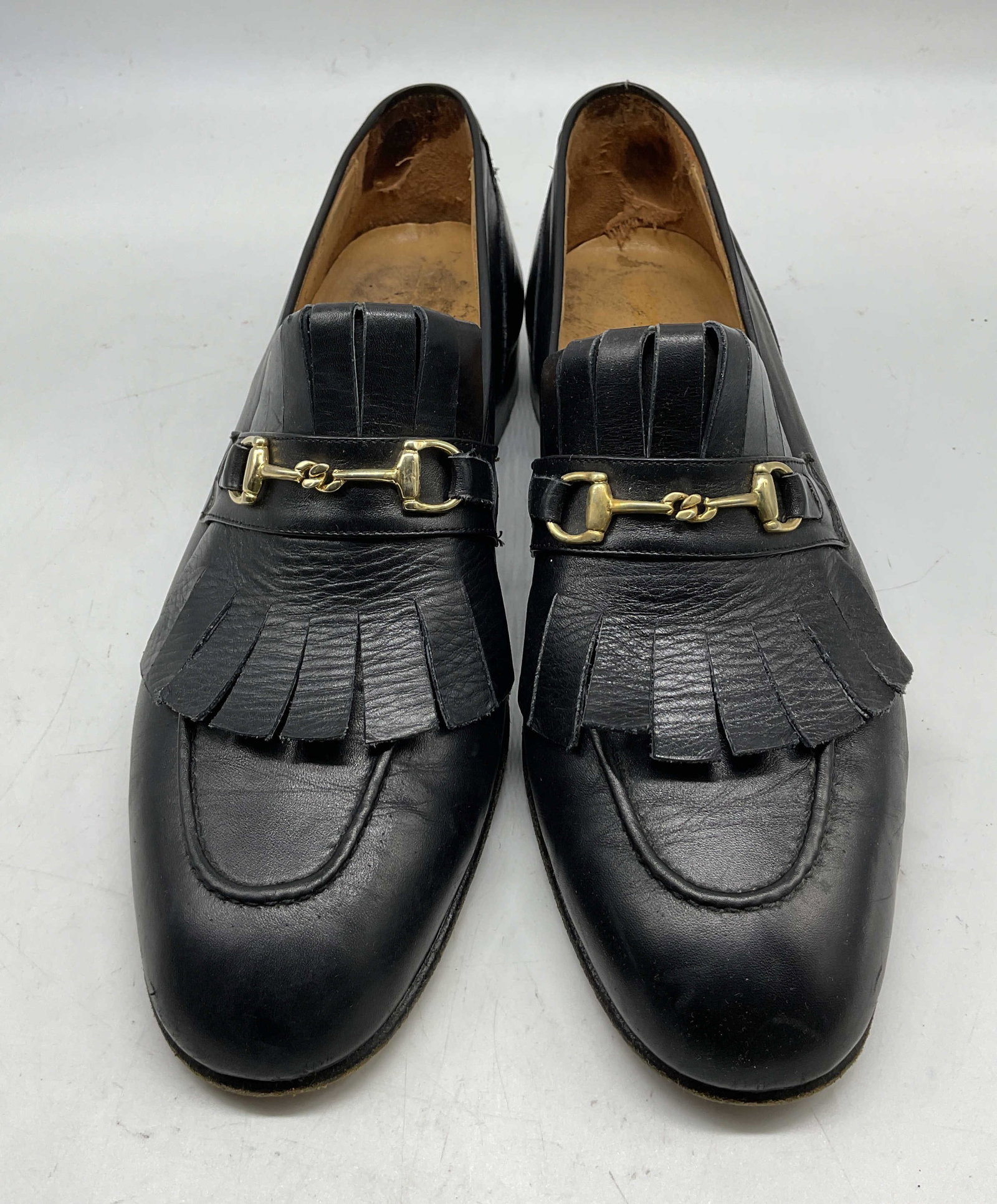 Vintage Black Leather Loafers Italy: Vintage black leather loafers. Made in Italy. Brand name reads illegibly. Size 8.5M. Heeled shoe. Fringed and gold toned buckle accent. Wear consistent with exposure. Loafers, shoes, wearables,