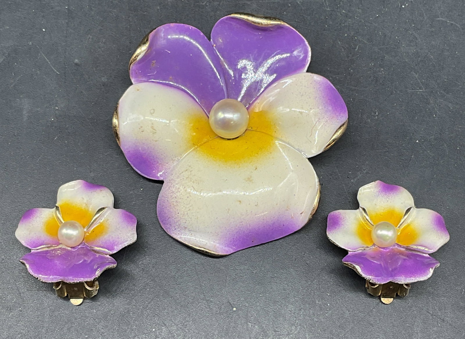 Lot 2 Marvella Enamel Flower Brooch & Earrings: Lot of 2 vintage matching jewelry pieces. Marvella gold tone enamel and faux pearl flower brooch and earrings. Brooch measures approx. 2 x 1.75 inches. Earrings measures approx. 1 x 1 inches. Some scr