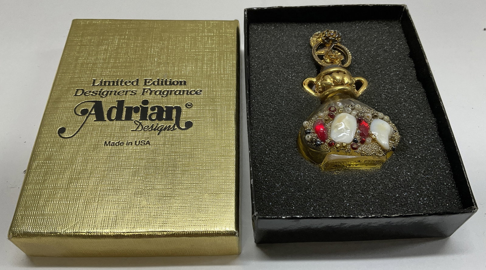 VTG Adrian ITALIAN Glass Jeweled Perfume Bottle: Vintage Adrian Designs Italian Glass Perfume Bottle. Decorated with Gold-Toned Metal, White Stones, Red Jewels and Small Beads. Condition Consistent With Exposure. Measures app 2.5in H x 1.5in Diam. V