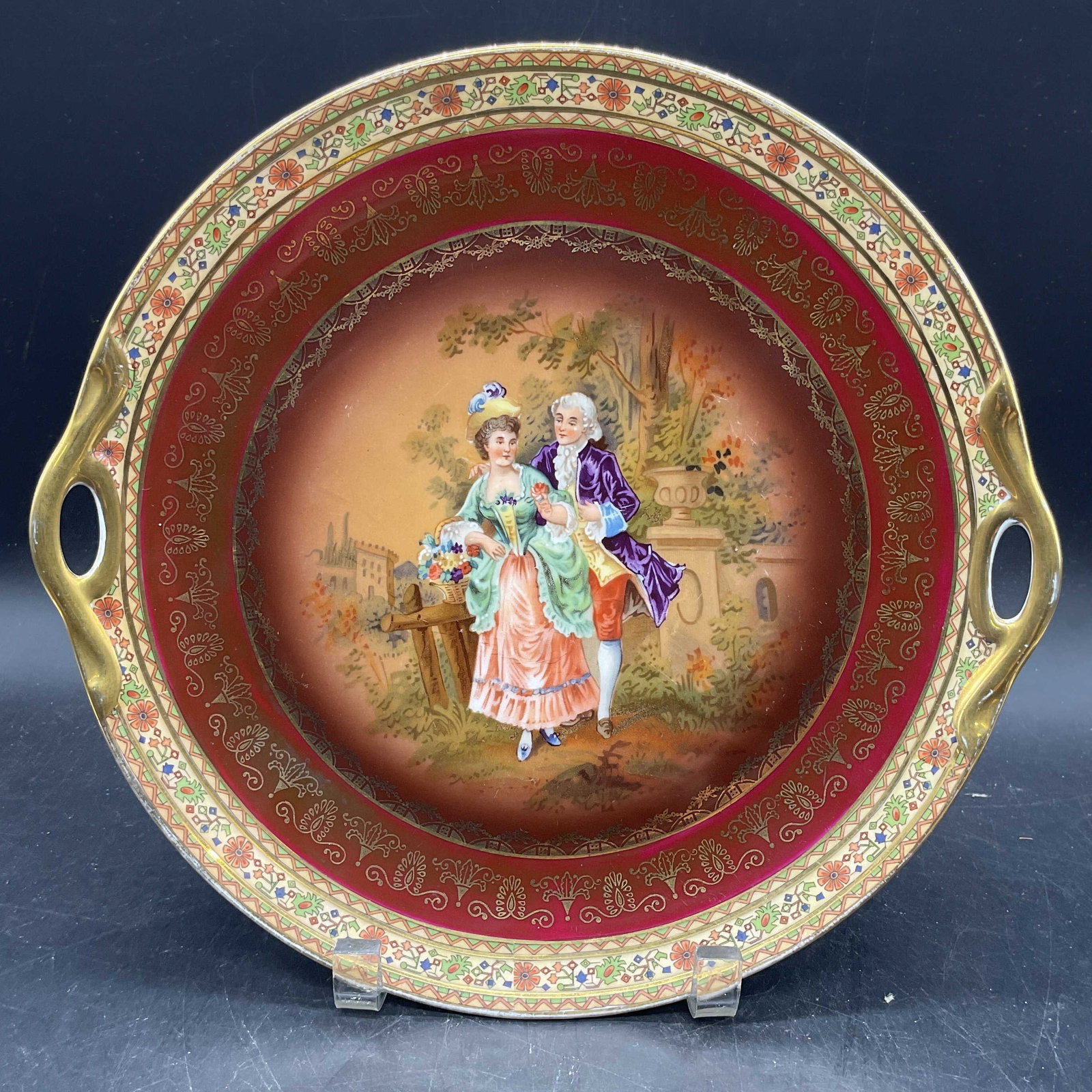 Rembrandt Porcelain Couple Platter Czechoslovakia: Circa 1920s/30s Rembrandt porcelain platter with handles. Made in Czechoslovakia. Hand painted and gilt decoration. Central couple motif with ornate floral scroll border. Measures approx. 11 inches