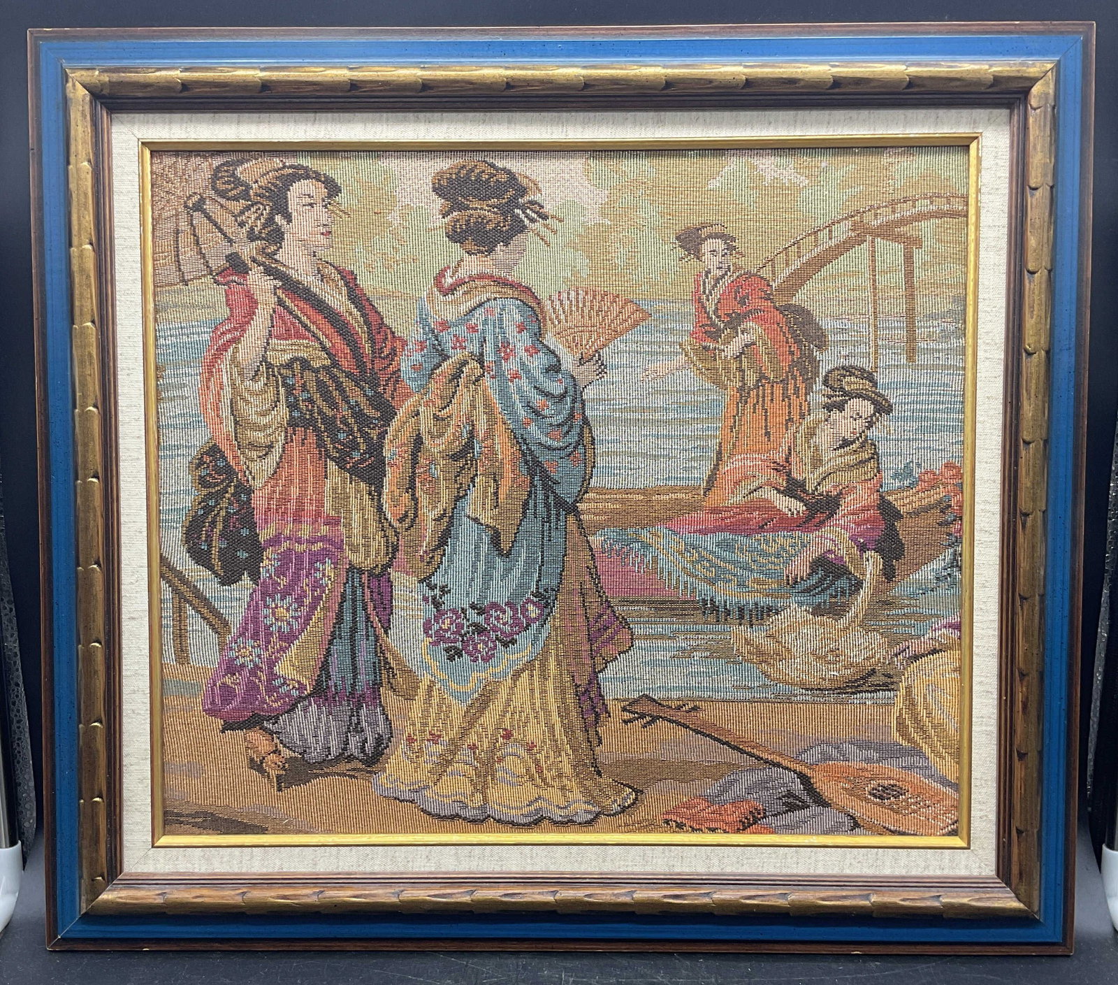 Framed Japanese Geisha Needlepoint Tapestry: Framed needlepoint tapestry. Japanese geisha scene. Gilt blue wood frame. Not examined out of frame. Frame measures approx. 19 x 21 inches. Some wear consistent with exposure. Art, framed art,