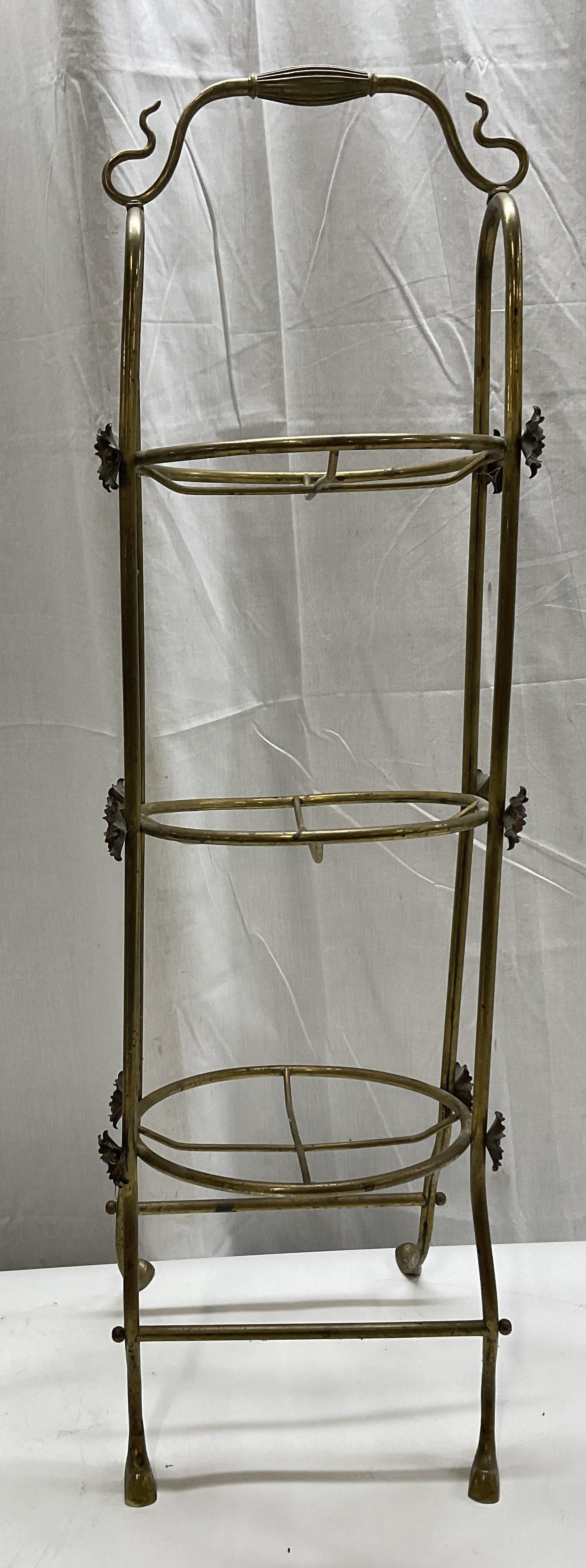 VTG Art Nouv Sty Brass Tiered 33.75in Cake Stand: Vintage Art Nouveau Style Brass Tiered Cake Stand. Floral Accents on Sides. Tarnishing Present. Some Wobble. Measures app 33.75in H x 10in L. Vintage, Art Nouveau, Brass, Tiered, Cake Stand, Florals,