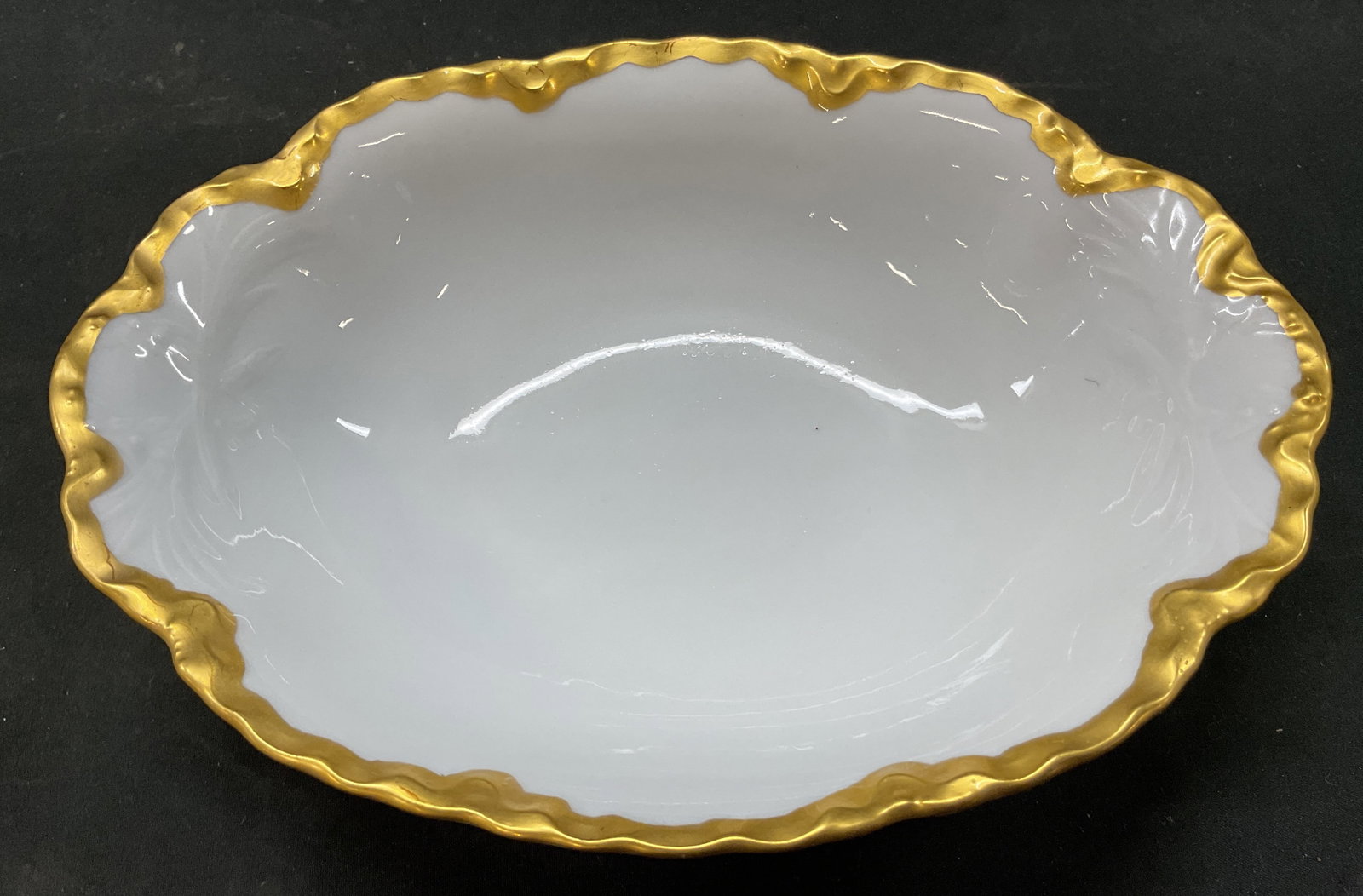 Hutschenreuther Selb Bavaria Bowl Germany: Hutschenreuther Selb Bavaria bowl. Marked on underside, reads Hutschenreuther Selb LHS Bavaria. Oval shaped bowl. Gilt scalloped edge. Embossed motifs. Measures ht approx 2 inches diam approx 9