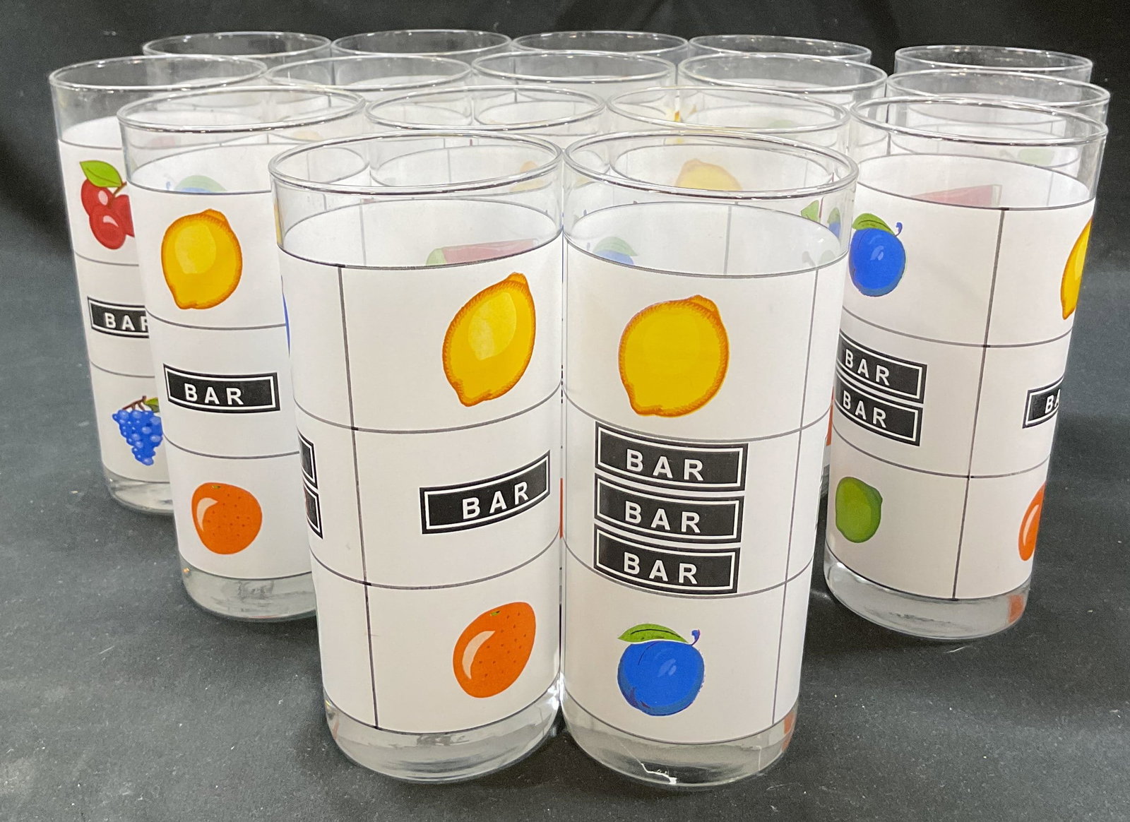 Set 16 Luminarc Casino Night High Ball Glasses: Set of 16 Luminarc Casino Night high ball glasses. Slot machine pattern. Reads bar with various fruit motifs. Varying colors. Measures ht approx 6.5 inches diam approx 3 inches. Scratching. High ball