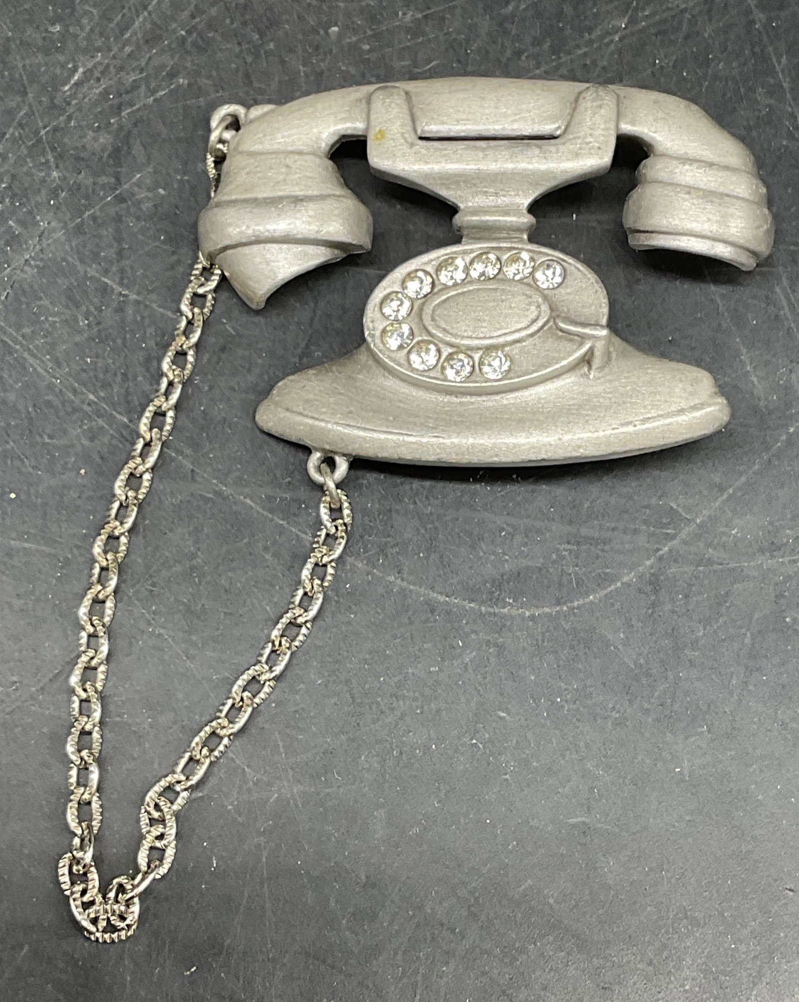 Jonette Silver Tone Crystal Telephone Brooch: Vintage JJ Jonette Jewelry silver tone and crystal telephone brooch with chain. Measures approx. 2 x 1.5 inches. Some scratching. Jewelry, estate jewelry, costume jewelry, cocktail jewelry, fashion je