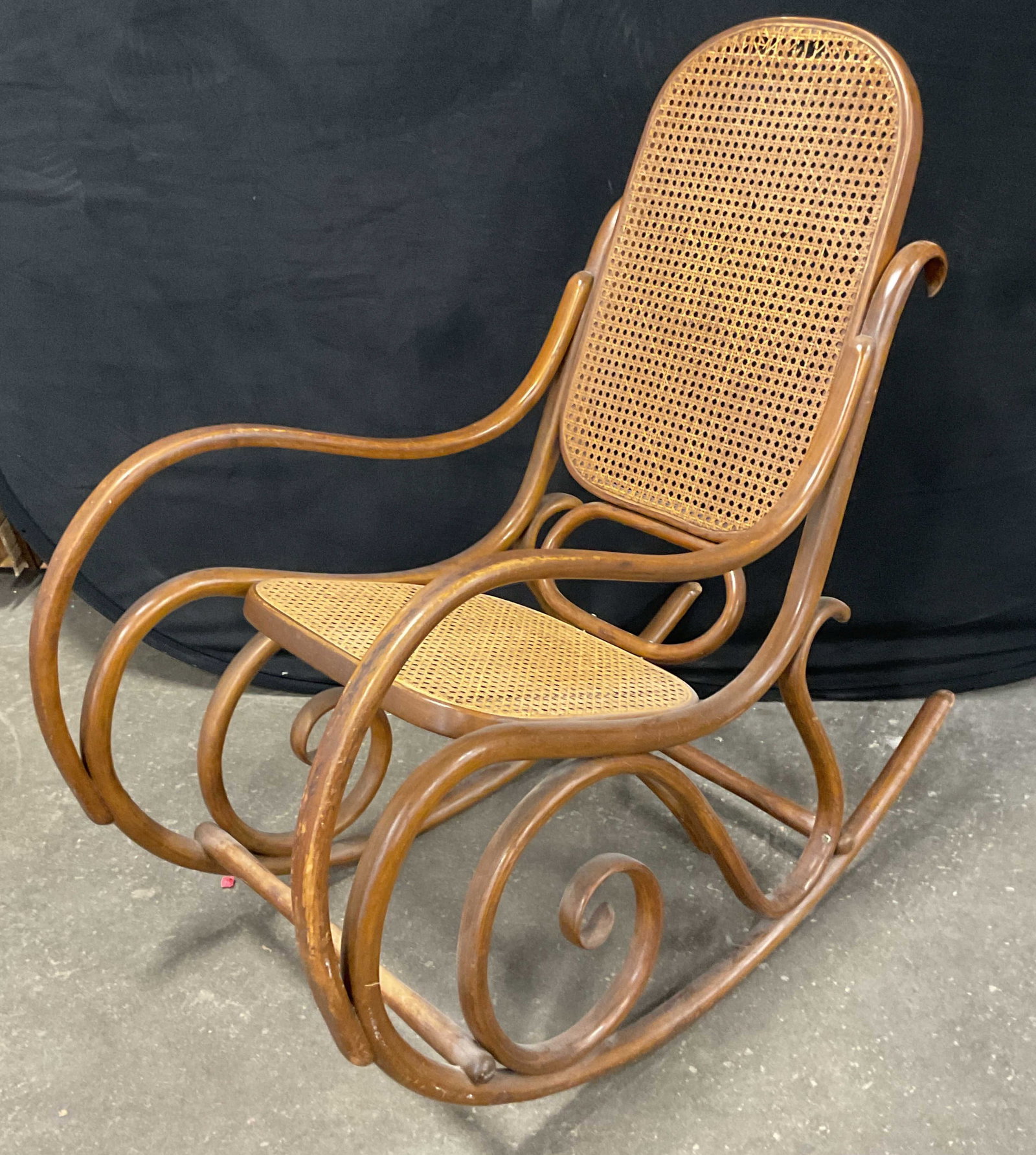 Thonet Style Bentwood & Cane Rocking Chair: Vintage Thonet style bentwood rocking chair with cane seat and backrest. Measures approx. 20 x 40 x 39 inches. Some scratching, loss to cane. Thonet style rocking chair, bentwood racking chair,