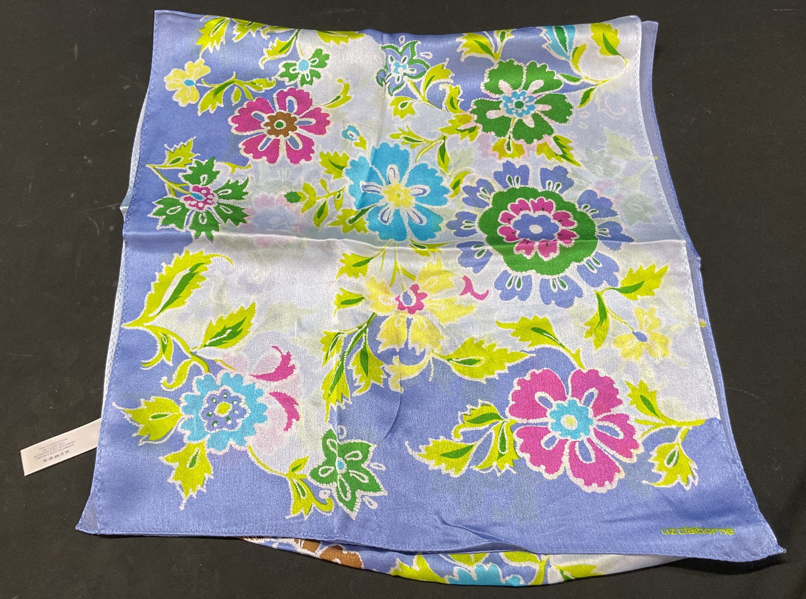 Liz Claiborne Floral Silk Scarf: Liz Claiborne floral silk scarf. Blue background. Floral motifs in varying colors. Measures approx 13 x 57 inches. Surface wear consistent with exposure. Scarf, Liz Claiborne, silk scarf, wearables,