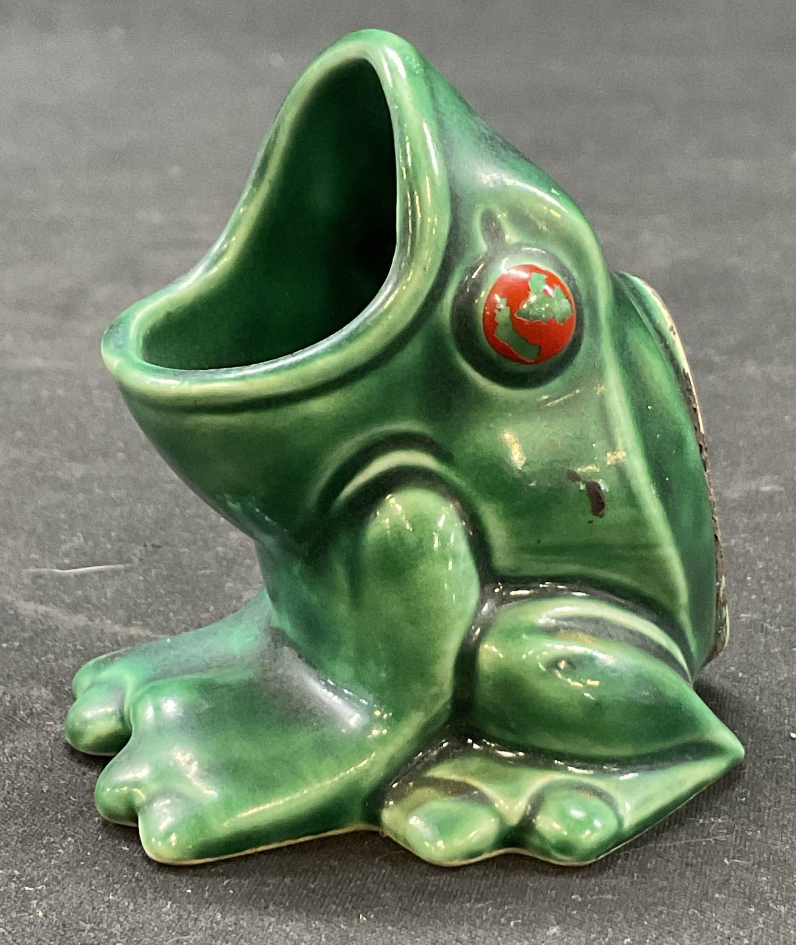 Goebel Ceramic Frog Match Holder Germany: Goebel ceramic frog match holder. Marked on underside. Made in Germany. Sitting frog figure with its mouth wide open. Green and red glazed. Measures approx 2.5 x 2.5 x 2.5 inches. Crazing and