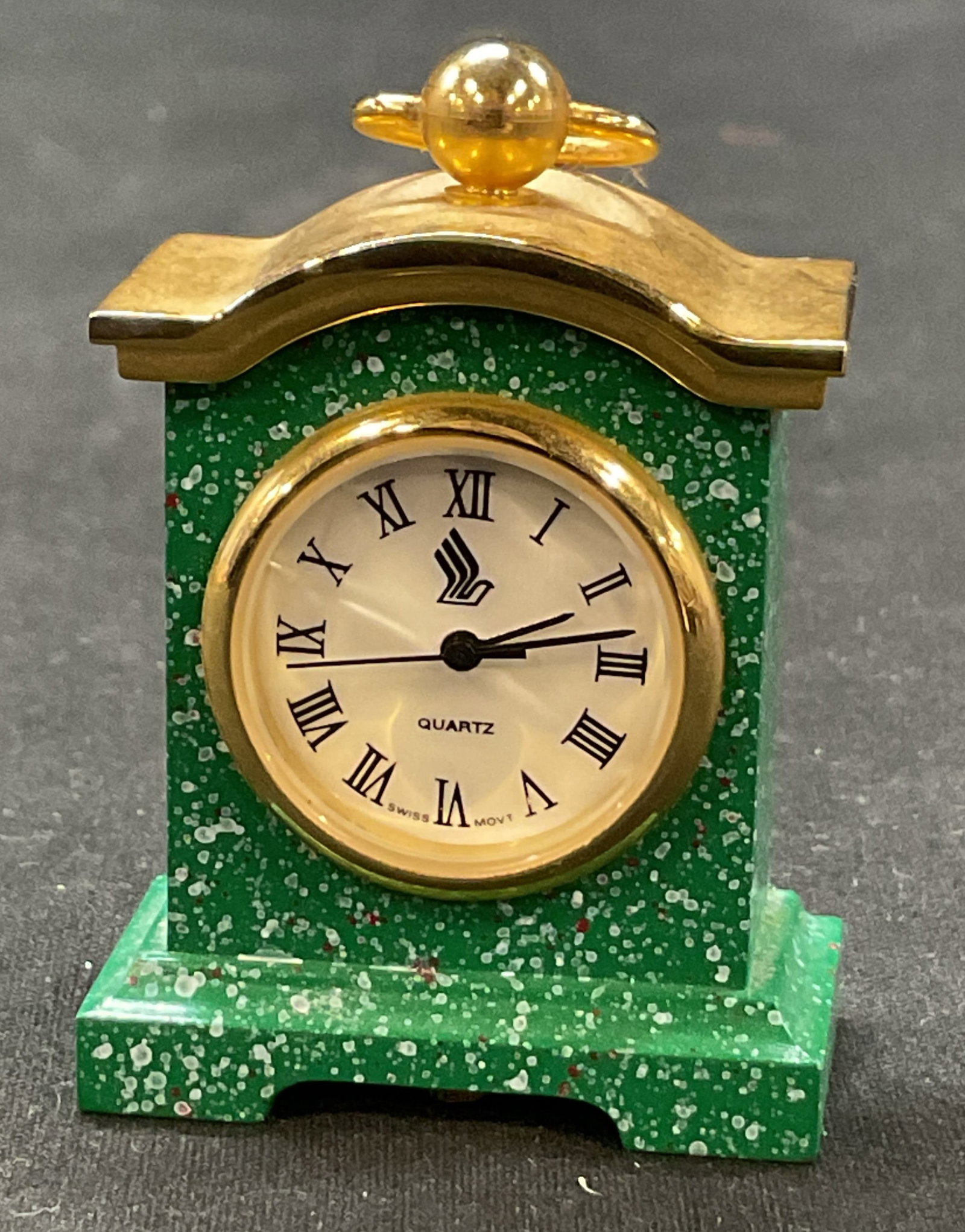 Singapore Airlines Mini Stone Desk Clock: Singapore Airline miniature stone desk clock. Green stone frame. Footed base. Gold toned top. Measures approx 1 x 1.5 x 2 inches. Not tested for function, sold as is. Surface wear consistent with