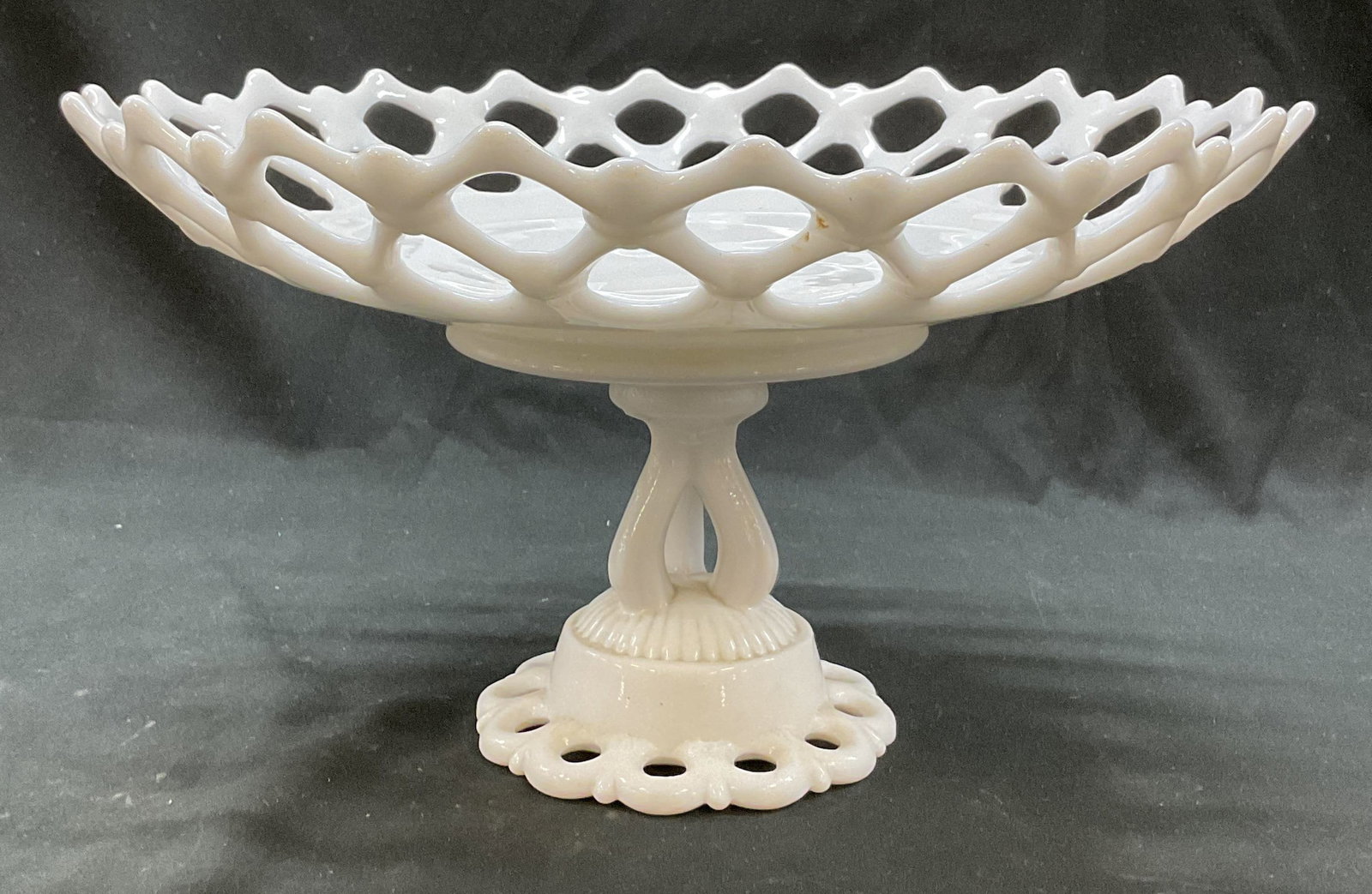 Westmoreland Milk Glass Pedestal Bowl: Westmoreland milk glass pedestal bowl. Marked on underside. Round base with ribbed surface. Ornate stem design. Round bowl. Lattice design on rim. Measures ht approx 6.5 inches diam approx 11.5 inches