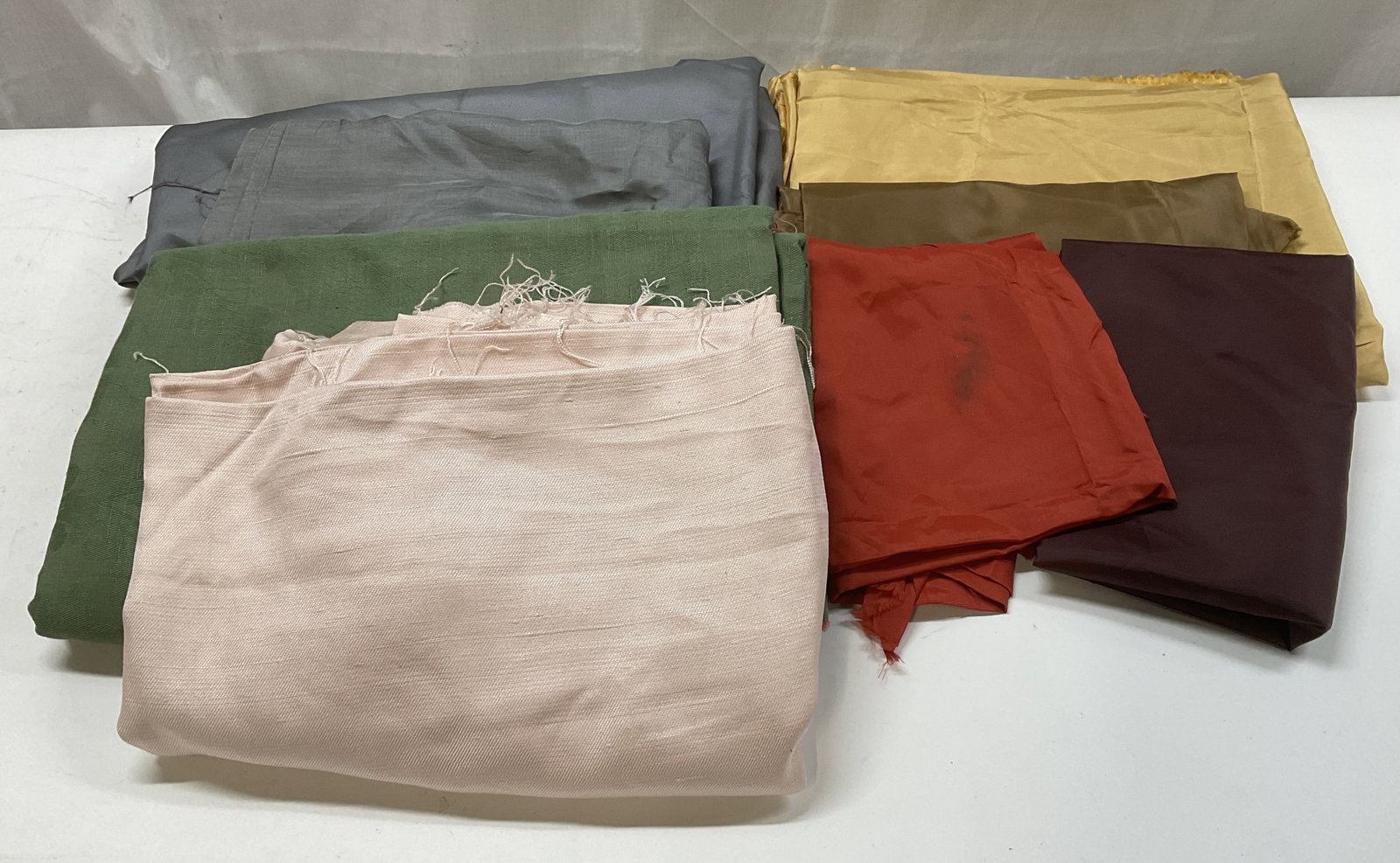 Lt8 Pieces of Fabric Scraps Silk+: 8 Pieces of Fabric Scraps. Material is Silk, Cotton, Linen, and More. Grey, Red, Maroon, Yellow, Brown, Green, and Pink. Not Measured, Unrolled, or Fully Inspected. Some Blemishes Present. Sold As Is.