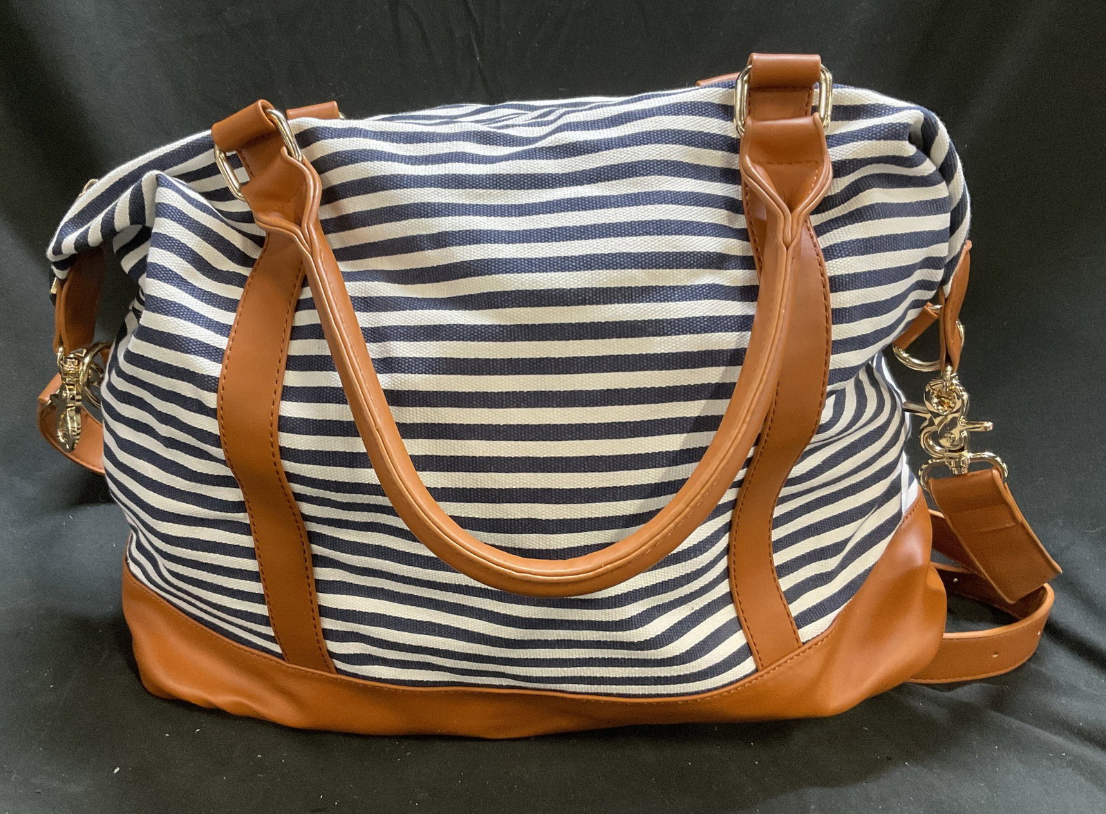 Blue & White Striped Canvas Tote Bag: Blue and White Striped Canvas Tote Bag with Brown Leather-Style Trim. Condition Consistent With Exposure. Comes with Lock on Zipper. No Key Present. Measures app 18in H x 16in W. Blue and White, Strip