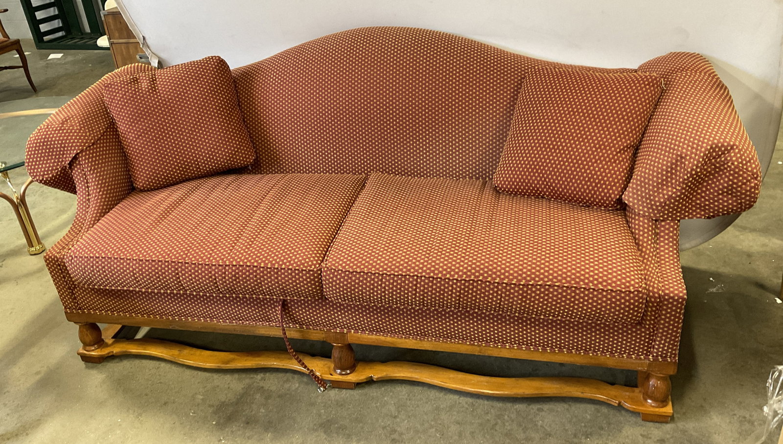 Traditional Americana Style Camelback Sofa: Traditional Americana Style Vintage Camelback Sofa. Rolled Arms. Curved Serpentine Crest Line. Red Patterned Cushions. Has Wear Present. Measures app 36in H x 85.5in L x 31in W. Traditional Americana 