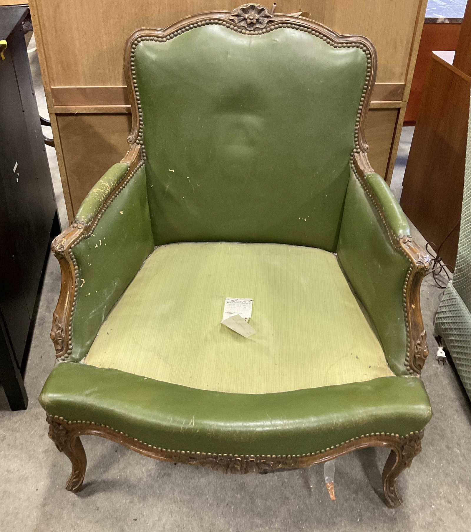 VTG DeGaal & Walker Bergere Leather Armchair: Vintage DeGaal and Walker Bergere Olive Green Leather and Carved Wood Armchair. Body Padding Consists of Horse Hair and Hog Hair. Surface Wear Present. Missing Cushion. Measures app 36in H x 28in L x 