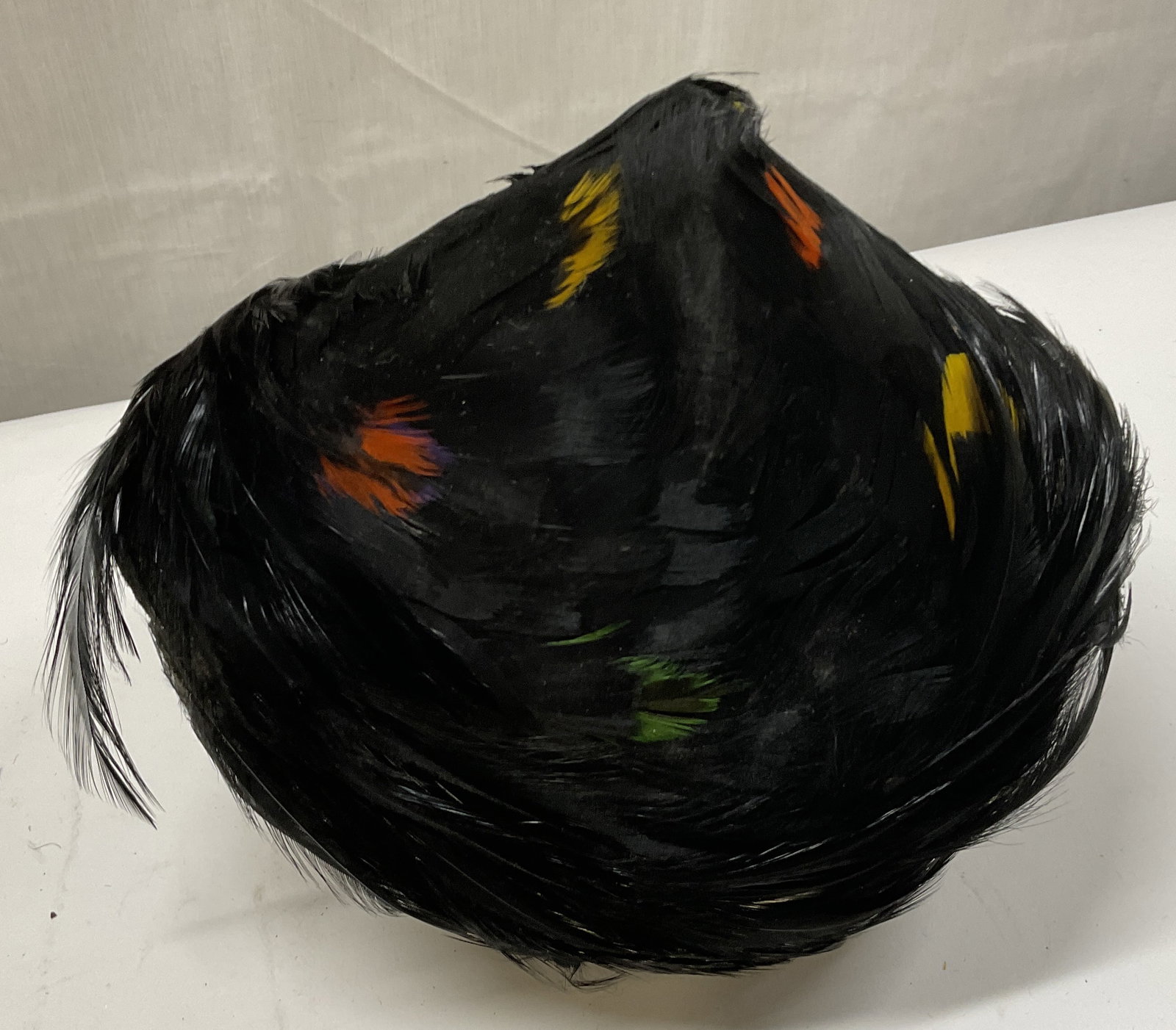 VINTAGE Multicolor & Black Feather Hat: Vintage Feather Hat. Black Feathers with Red, Yellow, and Green Feather Accents. Distinct Cone Shape at The Back. Some Imperfections. Measures app 7in H x 5in Head Diam. Vintage Hat, Feathers, Feather
