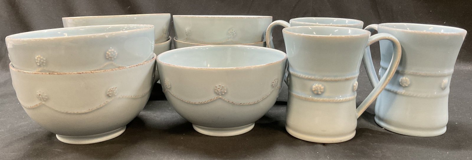 Set 10 SGND Juliska Berry & Thread Tableware: 10 piece Juliska ceramic blue berry and thread tableware. Signed Juliska on underside. Includes 7 bowls and 3 mugs. Berry and thread design, embossed. Measures ht approx 3.5 inches diam approx 6 inche