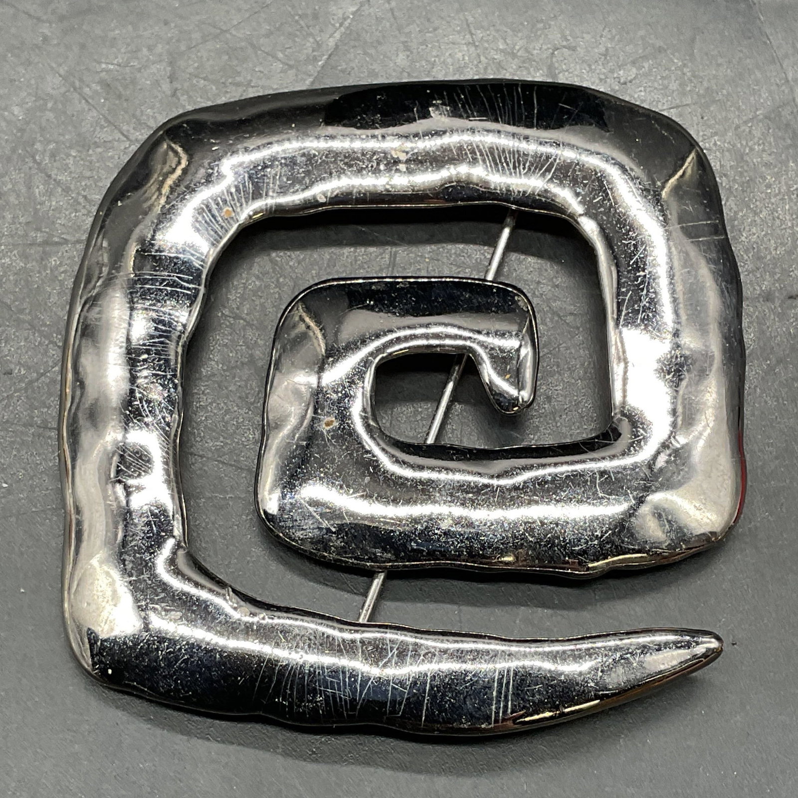 1986 JJ Silver Tone Square Swirl Brooch: 1986 signed JJ JONETTE Jewelry silver tone square swirl brooch. Measures approx. 2.25 x 2.25 inches. Some scratching. Property of Upper East Side French stage and screen actors estate, Manhattan. Jewe