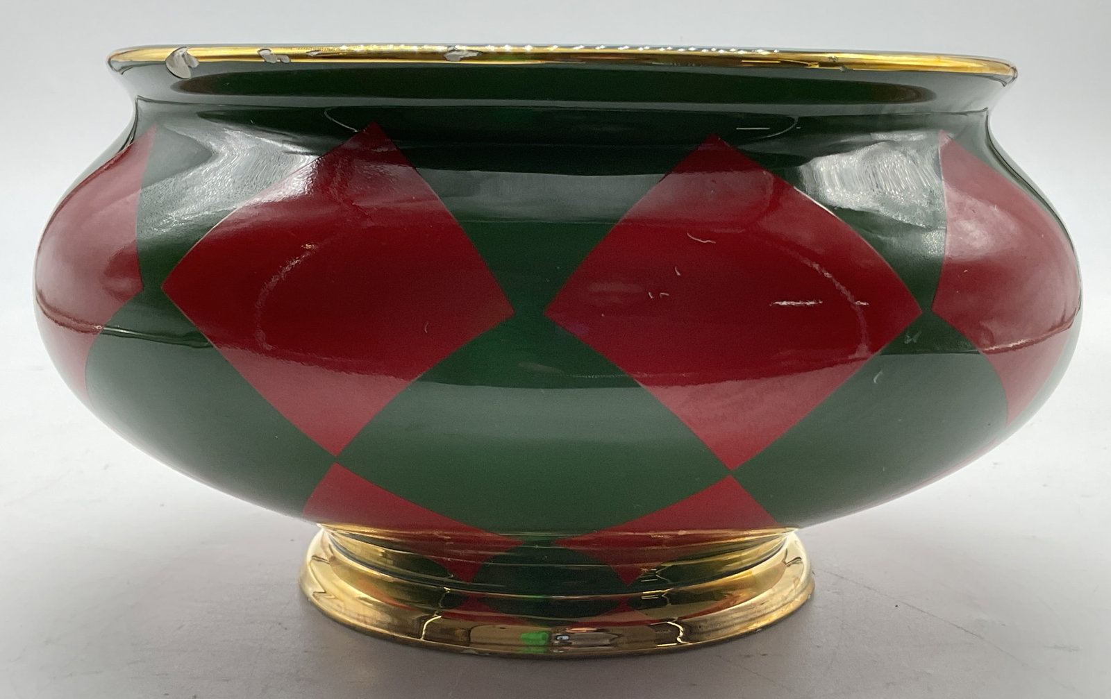 Teleflora Ceramic Bouquet Harlequin Bowl: Teleflora ceramic bouquet harlequin bowl. Marked on underside, reads Teleflora Gift. Round bowl with short pedestal base. Gilt rims. Green background with hand painted red diamond pattern. Measures ht