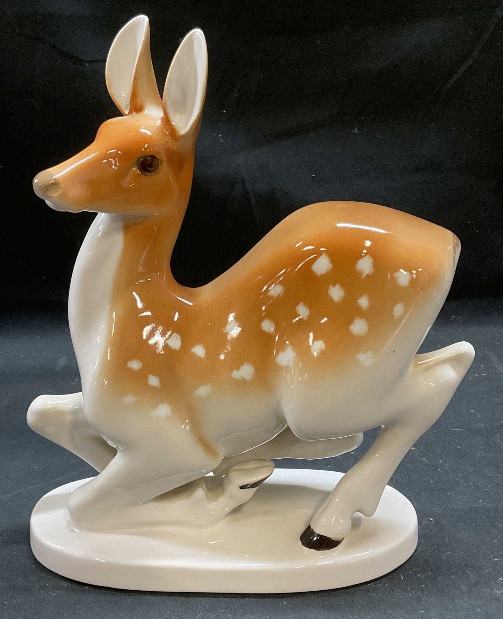 LOMONOSOV Porcelain Deer Fawn Figurine, Russia: Vintage Lomonosov porcelain recumbent deer fawn figurine. Signed. Made in Russia. Hand painted in white and tan. Measures approx 8 x 3.5 x 9.75 inches. Some wear consistent with exposure. LOMONOSOV fi