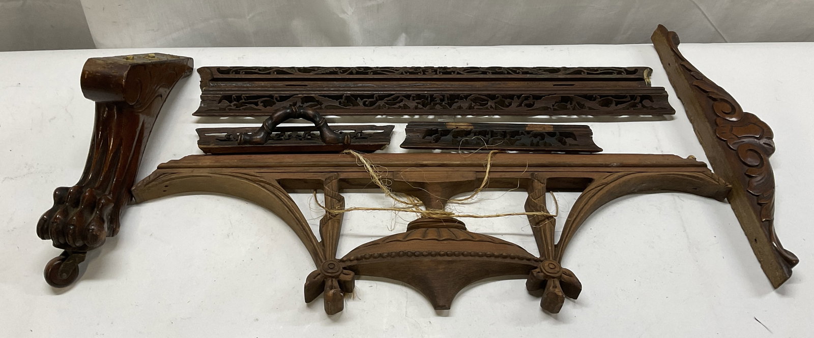 Lt7 Pieces of Carved Wooden Architectural Salvage: 7 Pieces of Carved Wooden Architectural Salvage. Intricate Carved Patterns, Urn Motif, and Clawed Foot on Caster. Scratching and Chips Present. Largest Measures app 7.5in H x 25in L x 7.5in W. Carved,