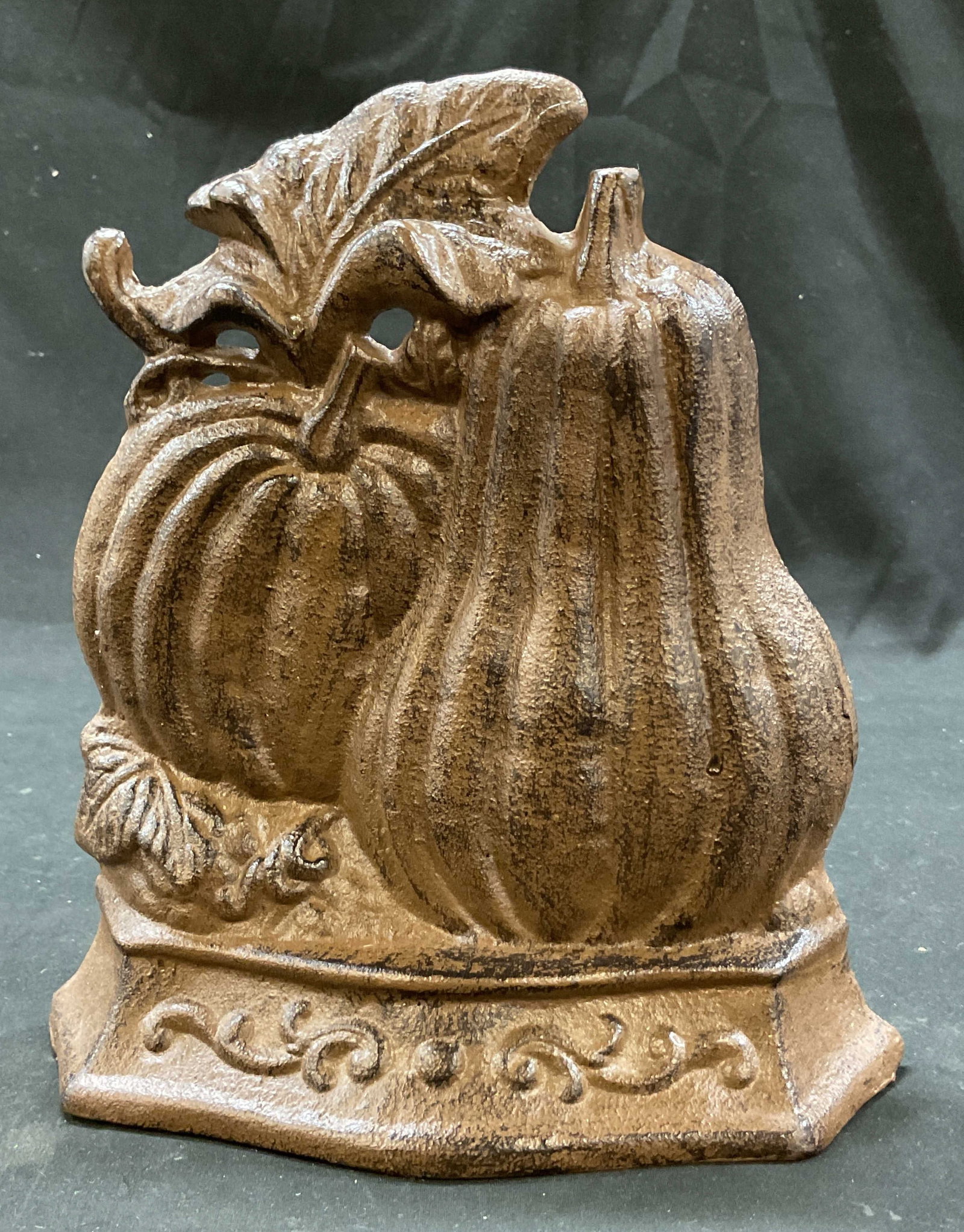 Halliwell Harvest Cast Iron Pumpkin Doorstop: Halliwell Harvest cast iron pumpkin doorstop. Marked Halliwell Harvest on backside. Pumpkin and squash motif. Leaf and scroll accents. Dark brown. Measures approx 2 x 8.5 x 8 inches. Scratching. Doors