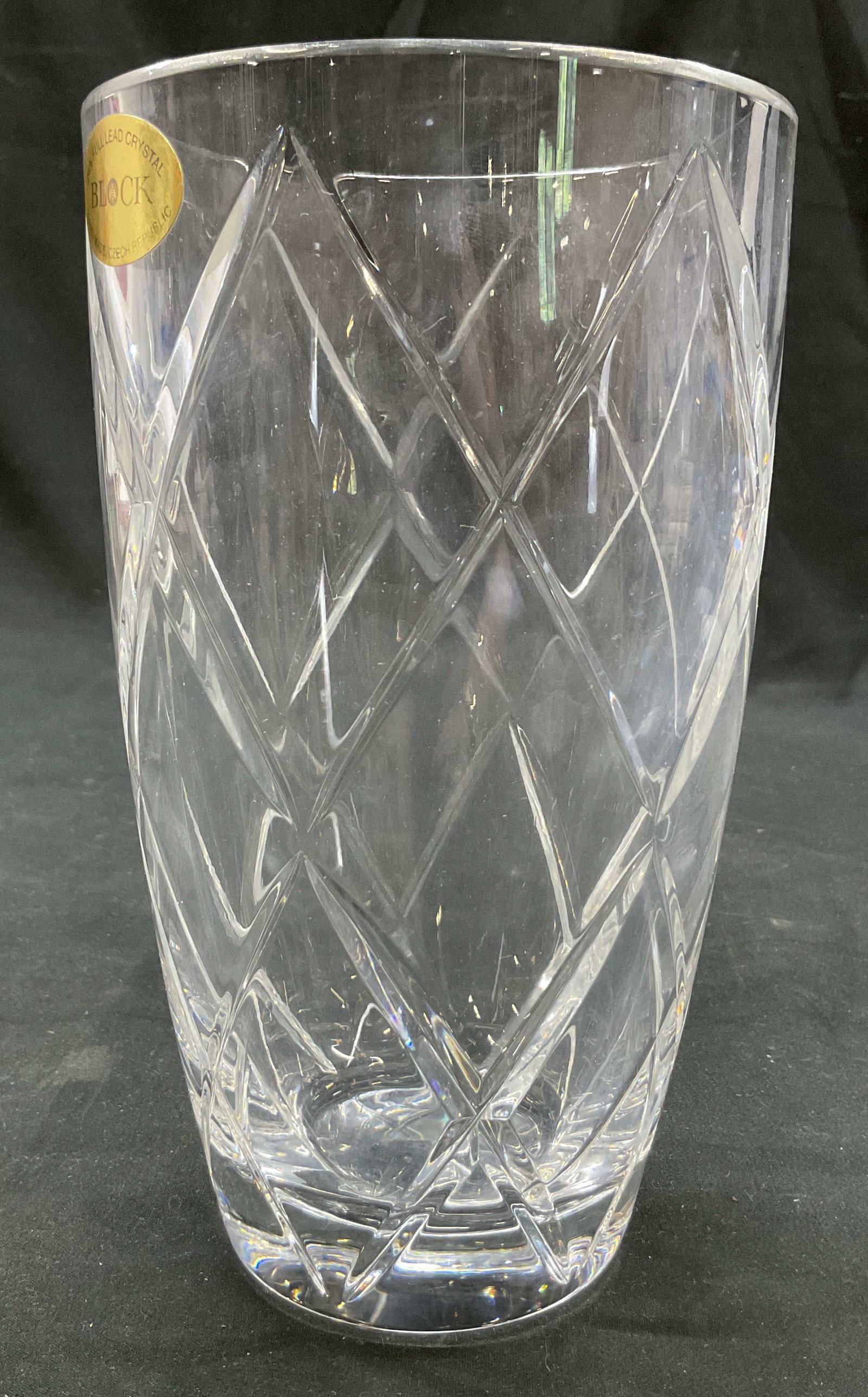 Block Cut Crystal Vase Czech Republic: Block cut crystal vase. Sticker adhered to surface. Hand Made in Czech Republic. Round wide rim and bulbous body. Cut diamond like pattern. Measures ht approx 7 inches diam approx 4 inches. Scratching