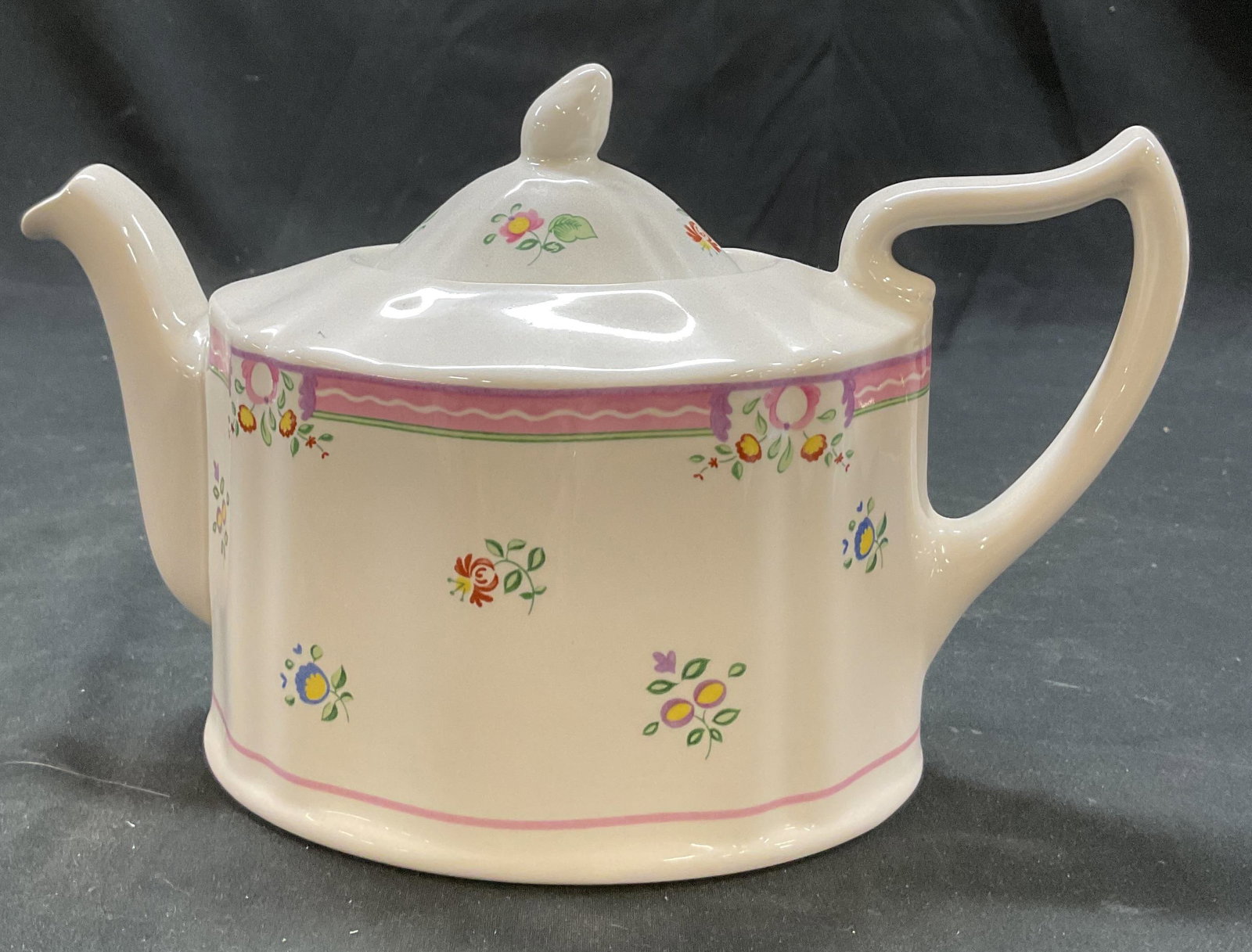 Laura Ashley Alice Porcelain Teapot England: Laura Ashley Alice porcelain lidded teapot. Marked on underside, reads Alice Exclusive To Laura Ashley Made In England. Scalloped edge and ribbed surface. Curved handle and spout. Alice pattern, flora