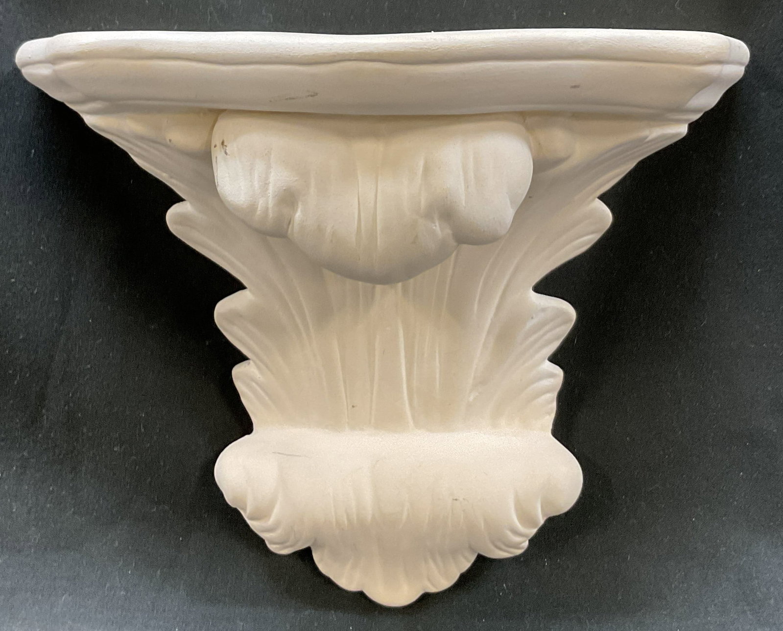 Vintage Bisque Ceramic Wall Shelf: Vintage bisque ceramic wall shelf. Scalloped edge. Carved lines. Abstract shape with scroll design. Measures approx 3.5 x 7 x 6 inches. Surface wear consistent with exposure. Wall shelf, wall decor, d