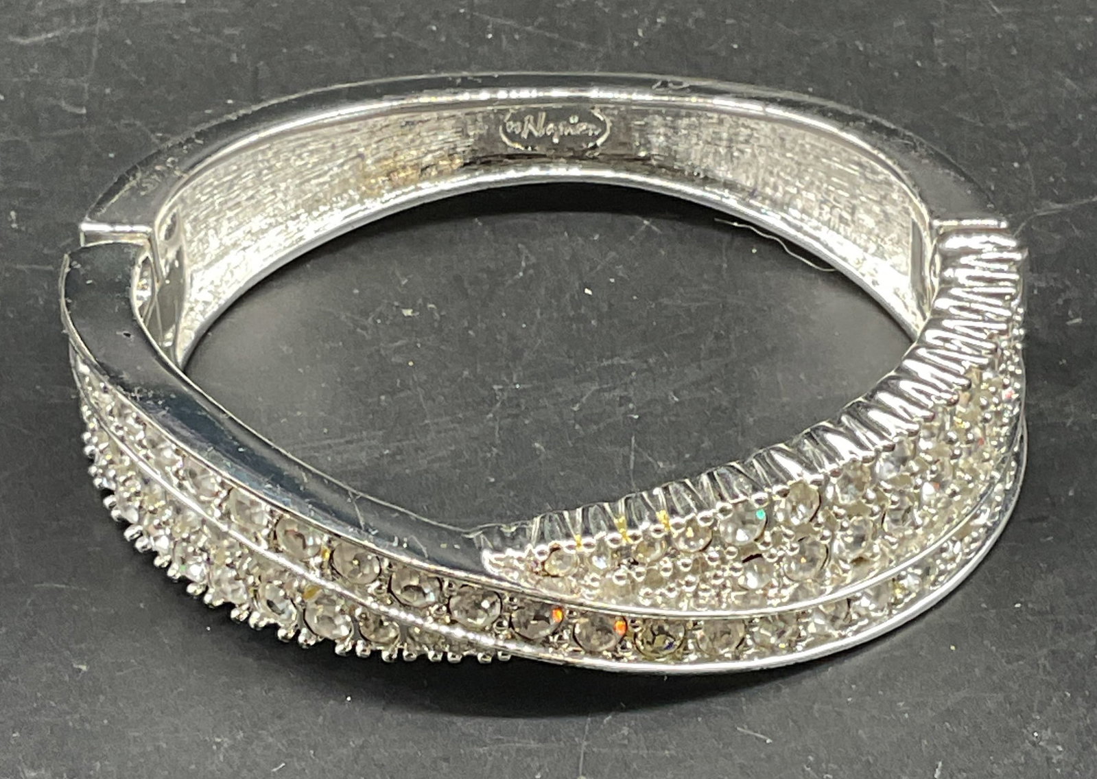 Vintage Napier Silver Tone Rhinestone Bracelet: Vintage Napier silver tone hinged bangle bracelet with crossover band and rhinestones. Measures approx. 2.25 inches wide. Some scratching. Jewelry, estate jewelry, costume jewelry, cocktail jewelry, f