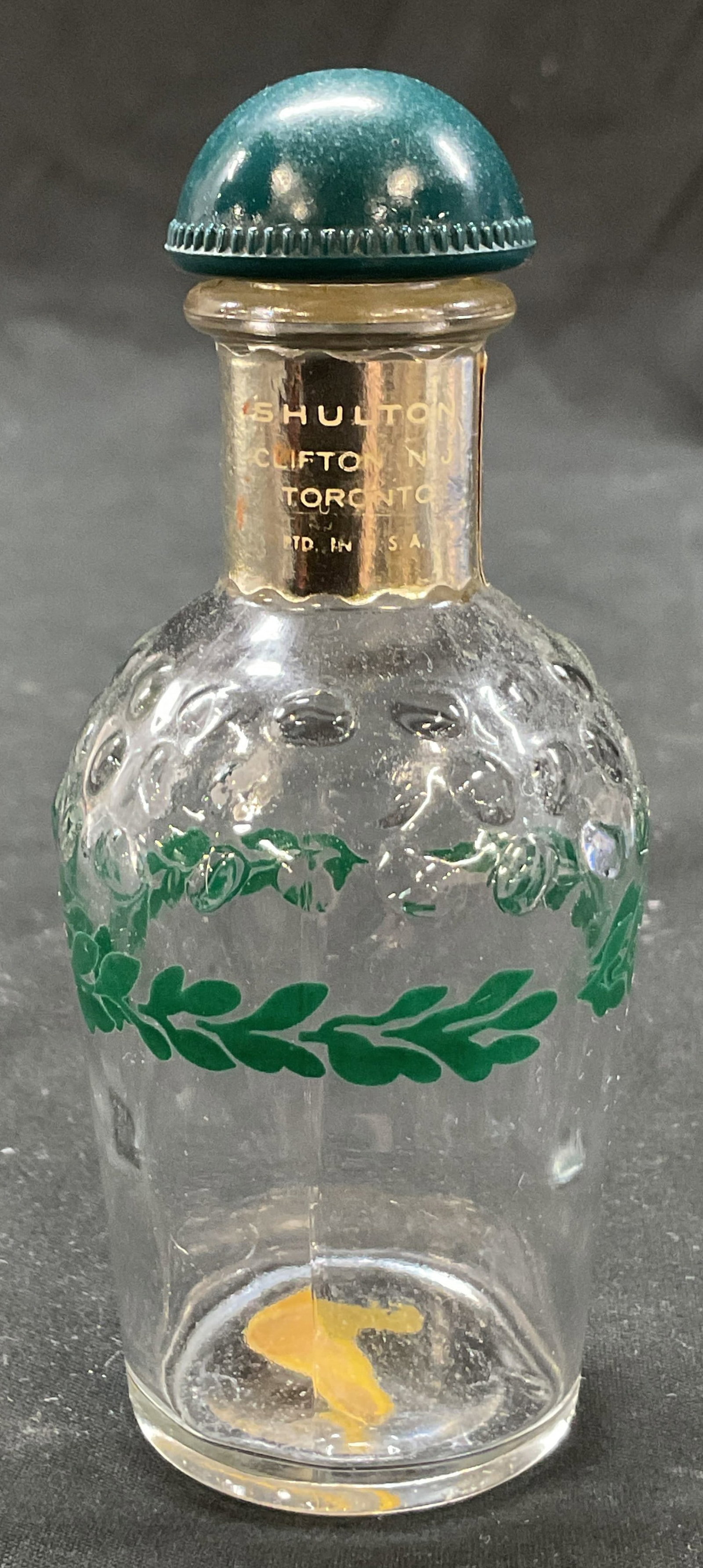 Shulton Friendships Garden Glass Perfume Bottle: Shulton Friendships Garden glass toilet water perfume bottle. Marked on surface. Green leaf pattern, painted. Raised dot pattern. Green dome lid. Measures ht approx 4.5 inches diam approx 1.5 inches. 