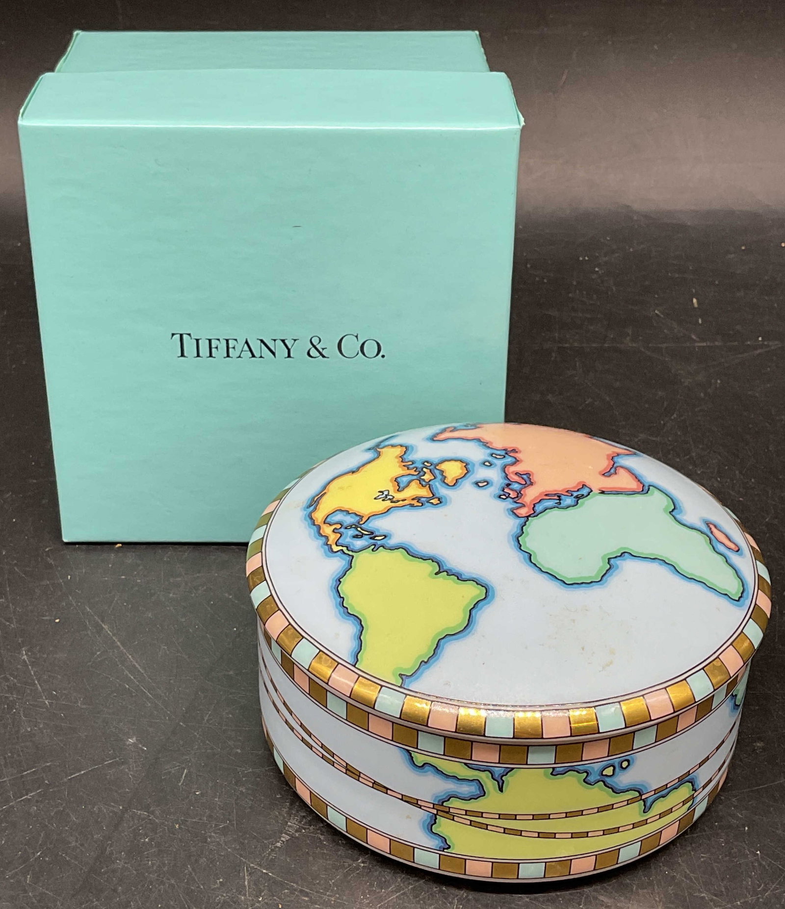 Tiffany & Co World Map Porcelain Trinket Box: Tiffany & Co porcelain trinket box, world map design. Made in Japan. Measures approx. 4 x 2 inches. Includes a gift box. Some scratching. Tiffany and co trinket box, map trinket box, porcelain trinket