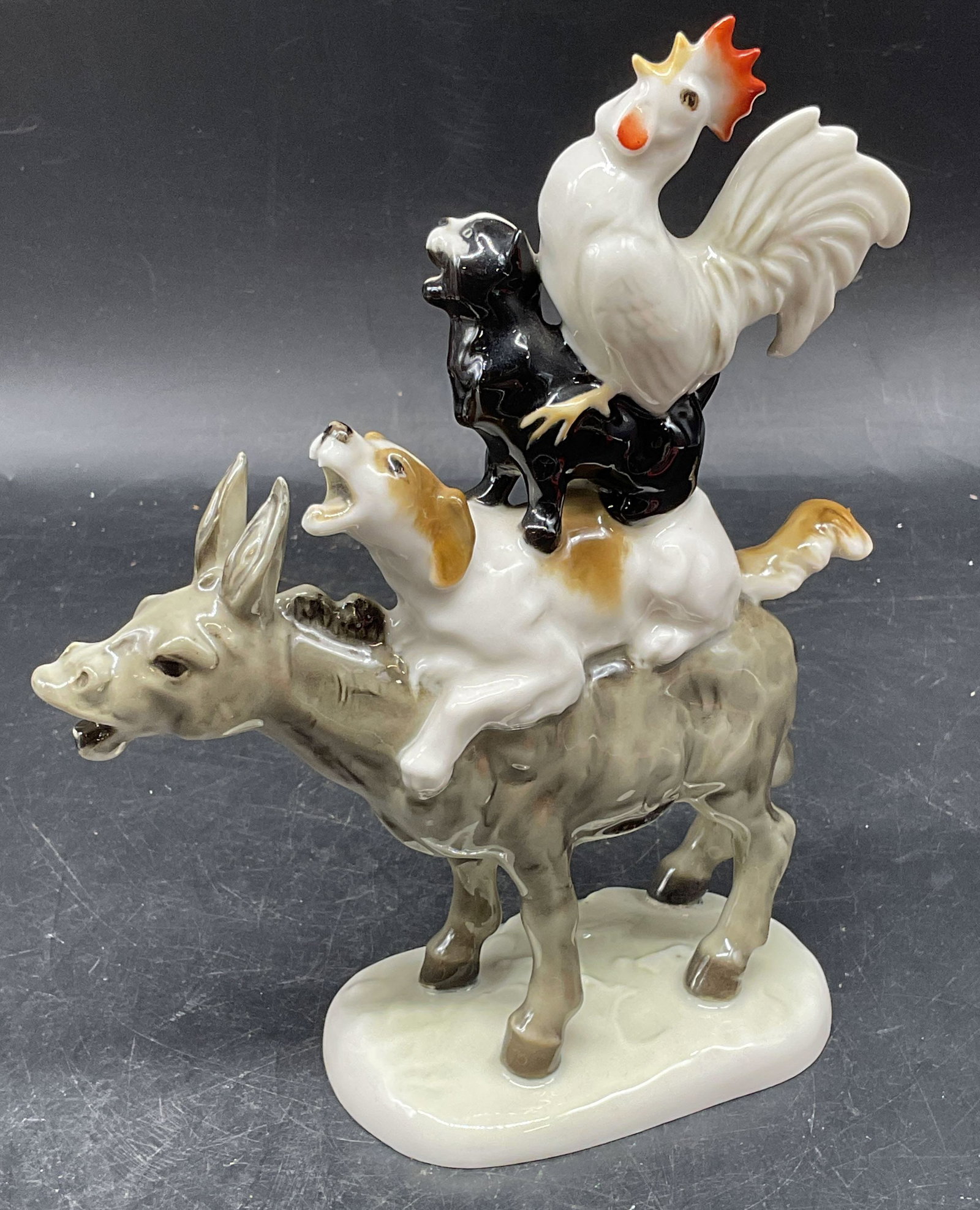 Hutschenreuther Bremen Town Musicians Figurine: Vintage Hutschenreuther porcelain figurine. Bremen Town Musicians. Donkey, dog, cat, rooster. Hand painted. Made in Germany. Measures approx. 6 x 2.5 x 7.25 inches. Some scratching. Hutschenreuther fi