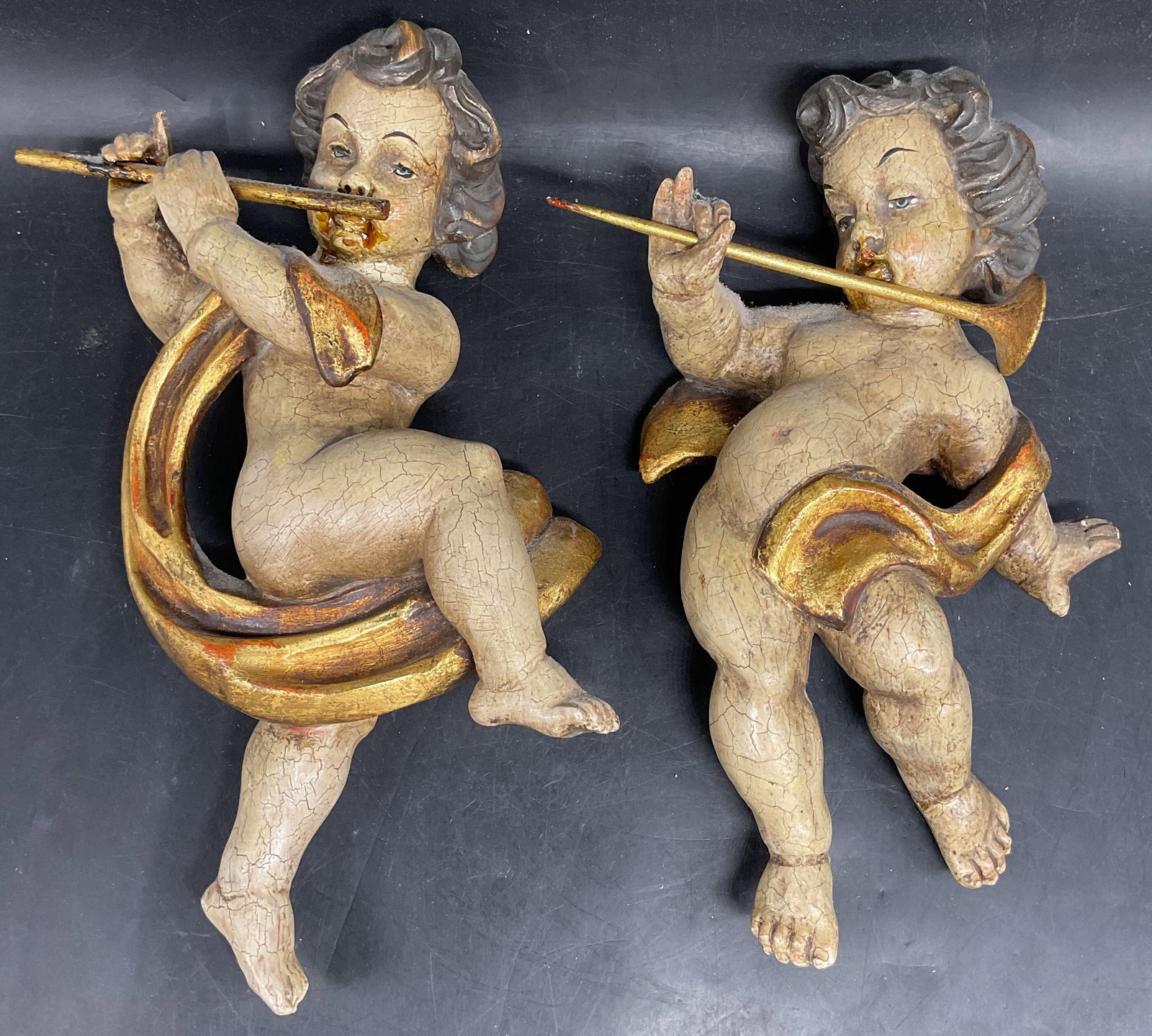 Pair Francesco Comploi Giltwood Putto Musicians: Pair of vintage Arte Sacra Francesco Comploi Ortisei Valgardena giltwood putto musicians. Carved and painted. Made in Italy. Sizes vary, piece with label measures approx. 11 x 6 x 2.75 inches. Some lo