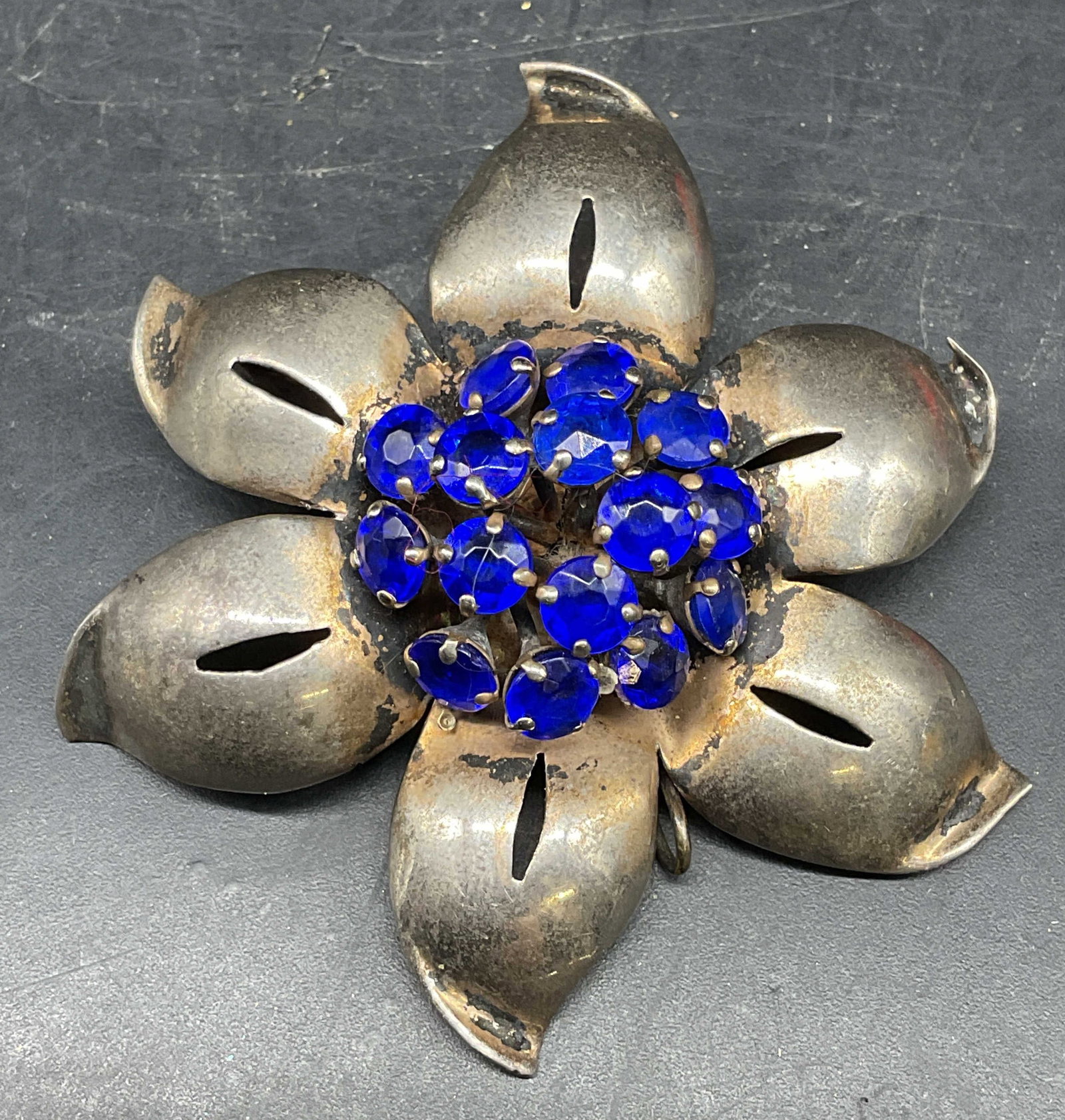 Sterling Silver Blue Rhinestone Flower Brooch: Vintage sterling silver flower brooch with blue rhinestones. Marked sterling. Measures approx. 2.5 inches wide. Some scratching. Jewelry, estate jewelry, costume jewelry, cocktail jewelry, fashion jew