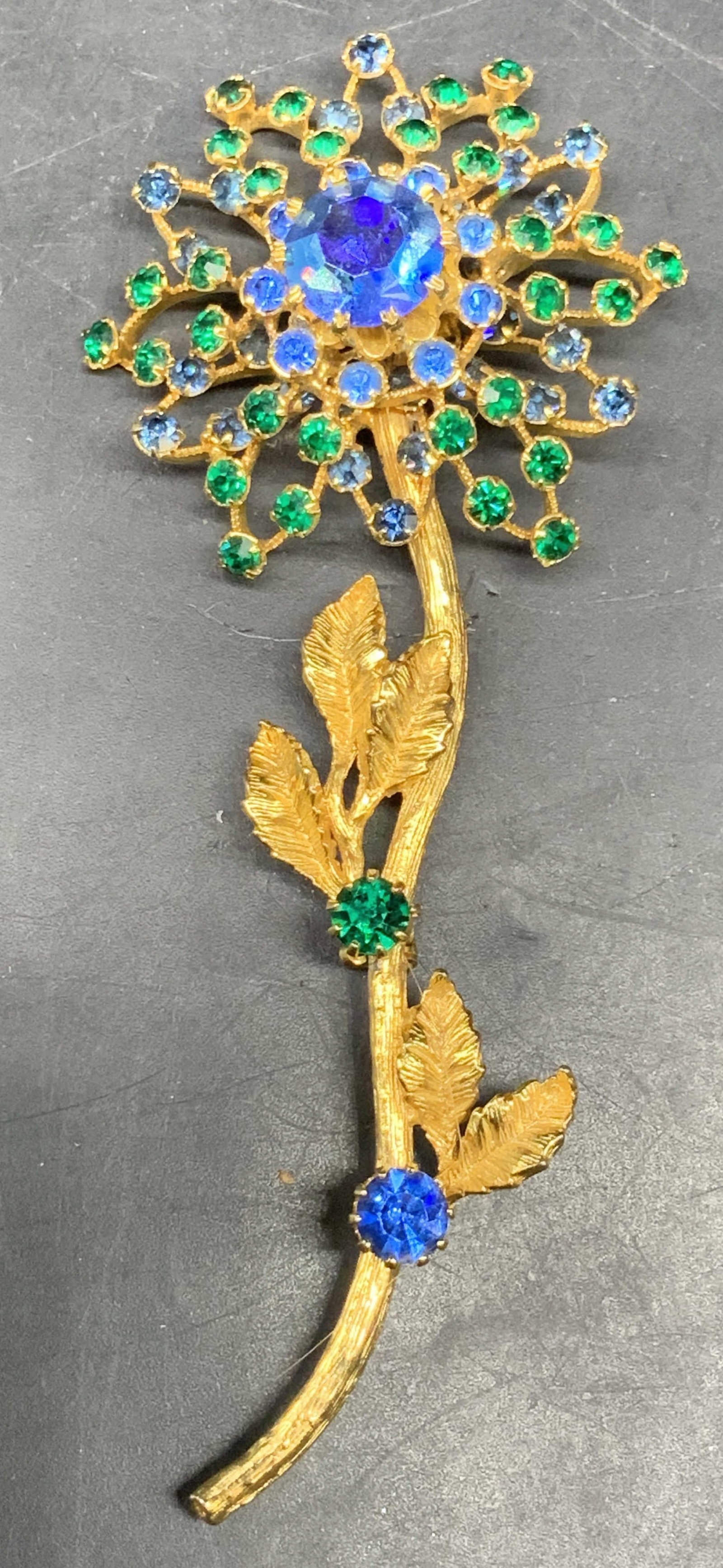 Vintage Gold Tn Austrian Crystal Flower Brooch: Vintage gold tone flower brooch with blue and green Austrian crystals. Made in Austria. Measures approx. 4.5 x 1.5 inches. Some scratching. Jewelry, estate jewelry, costume jewelry, cocktail jewelry, 