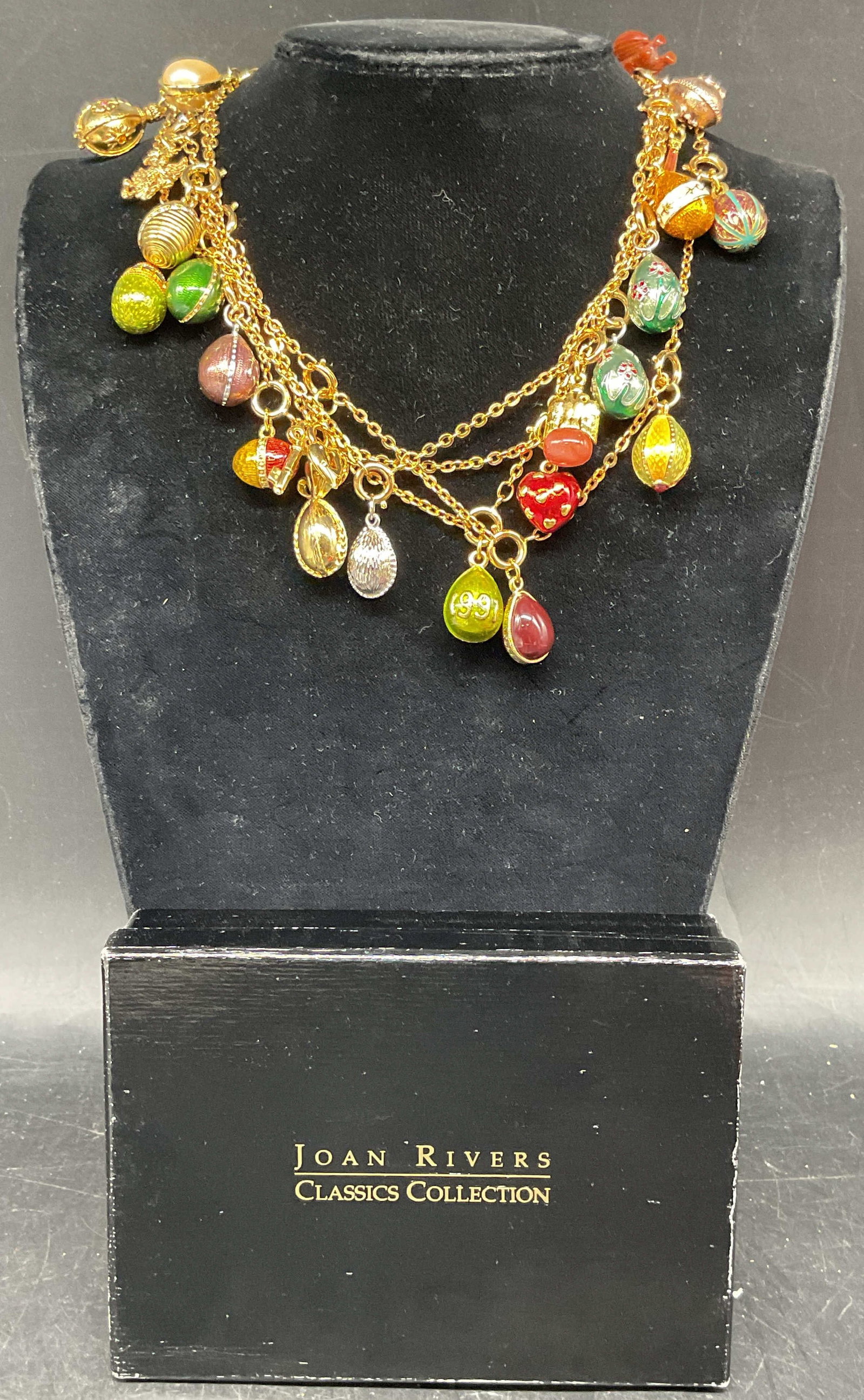 Vintage Joan Rivers Multi Egg Charm Necklace: Vintage Joan Rivers gold tone necklace with Faberge egg and other assorted charms. Enamel, lucite, and rhinestone. Drop length 34 inches. Includes box and dust bag. Some scratching. Jewelry, estate je